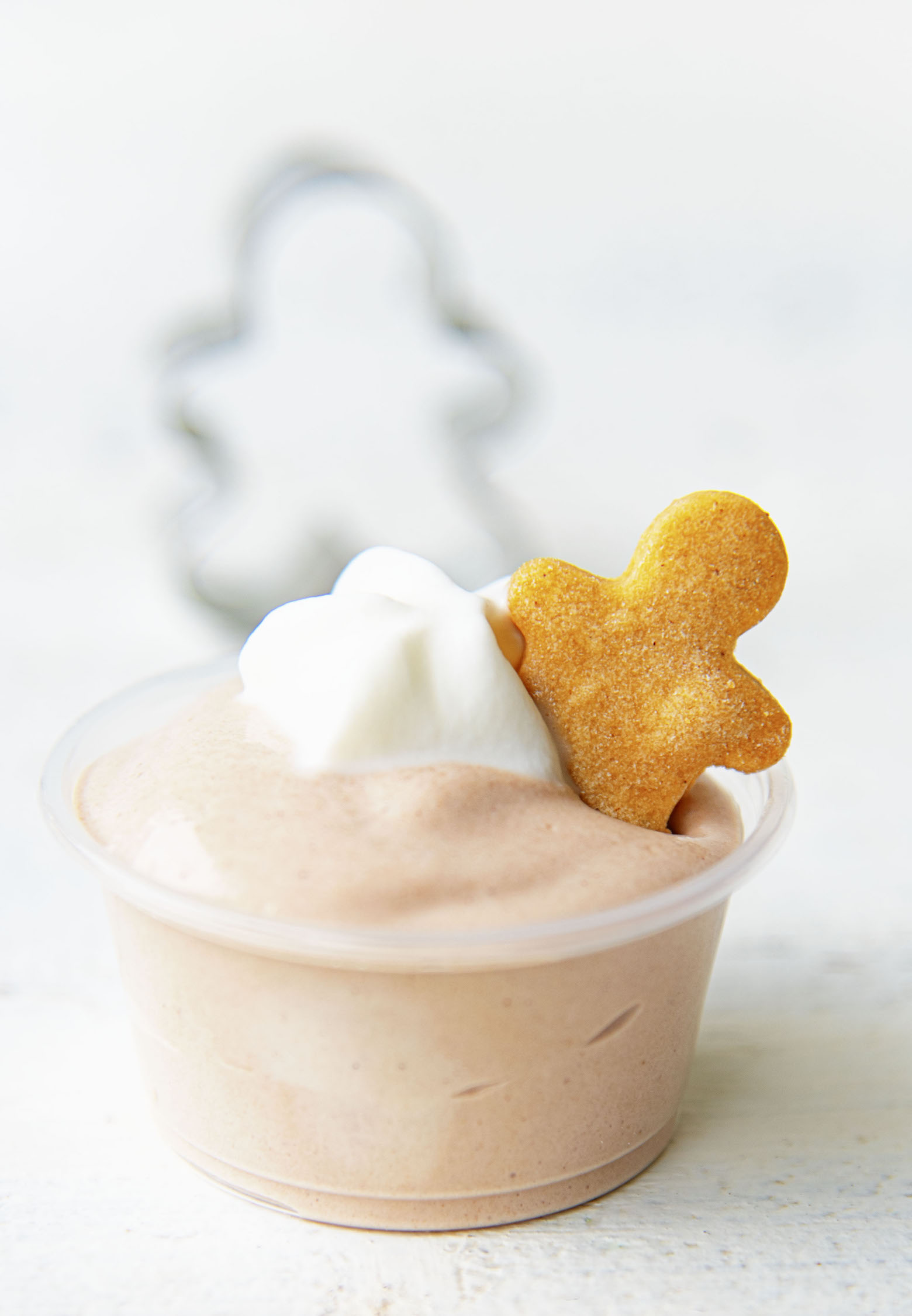 Close up of a Chocolate Gingerbread Pudding Shot with a gingerbread man cookie cutter in the background