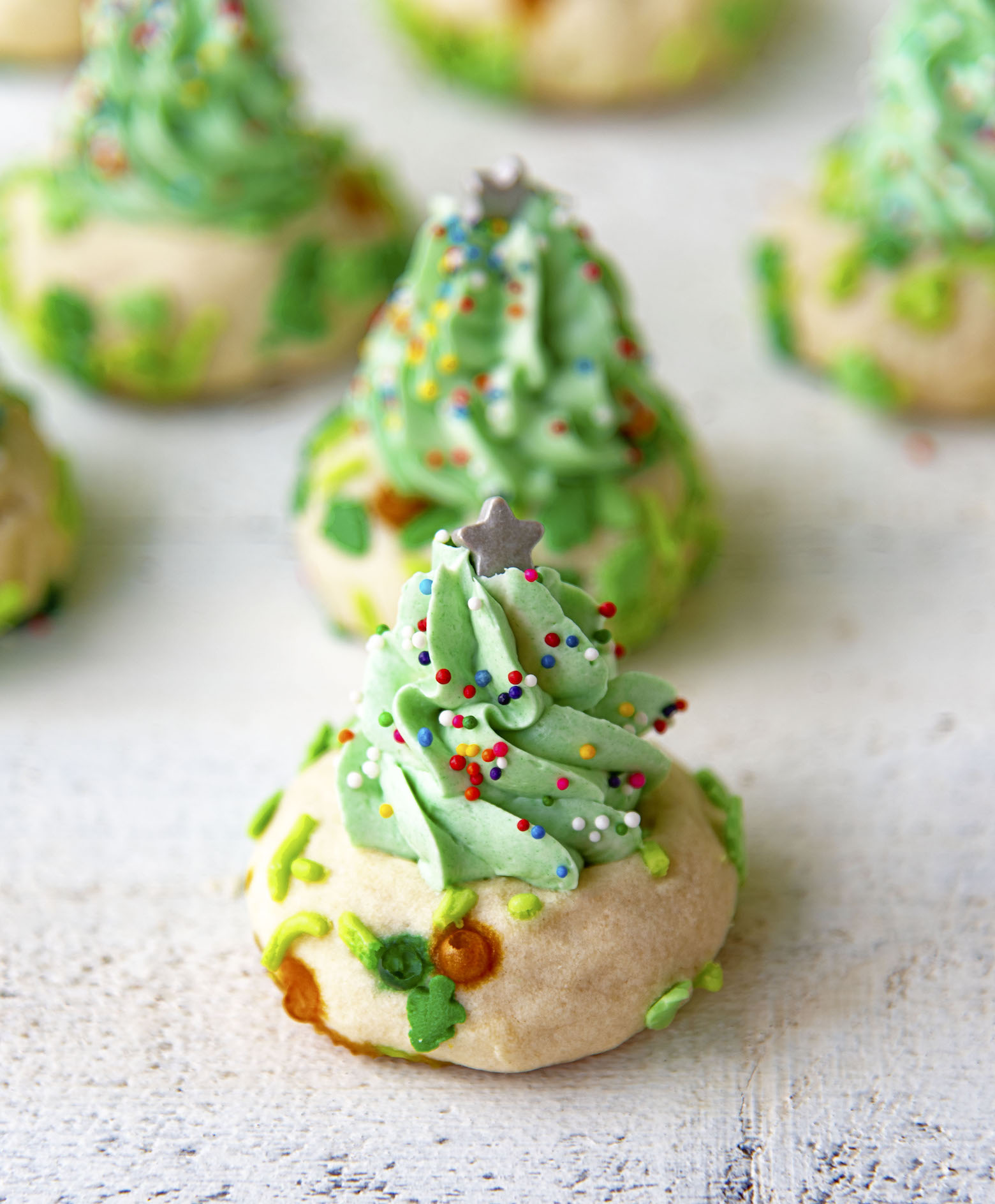 Several Christmas Tree Thumbprint Cookies with the first cookie in focus. 