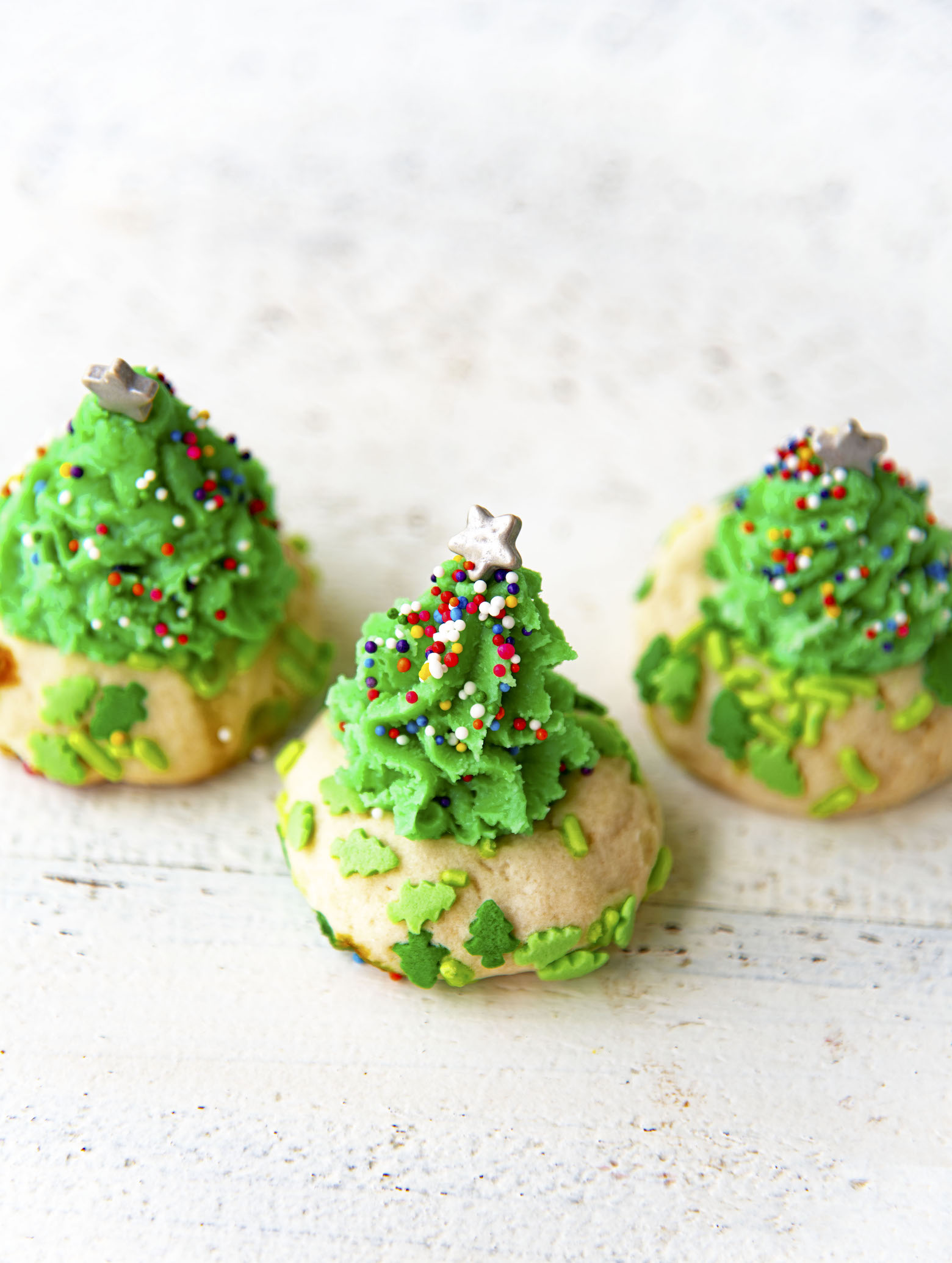 Three Christmas Tree Thumbprint Cookies using the fudge for the trees.
