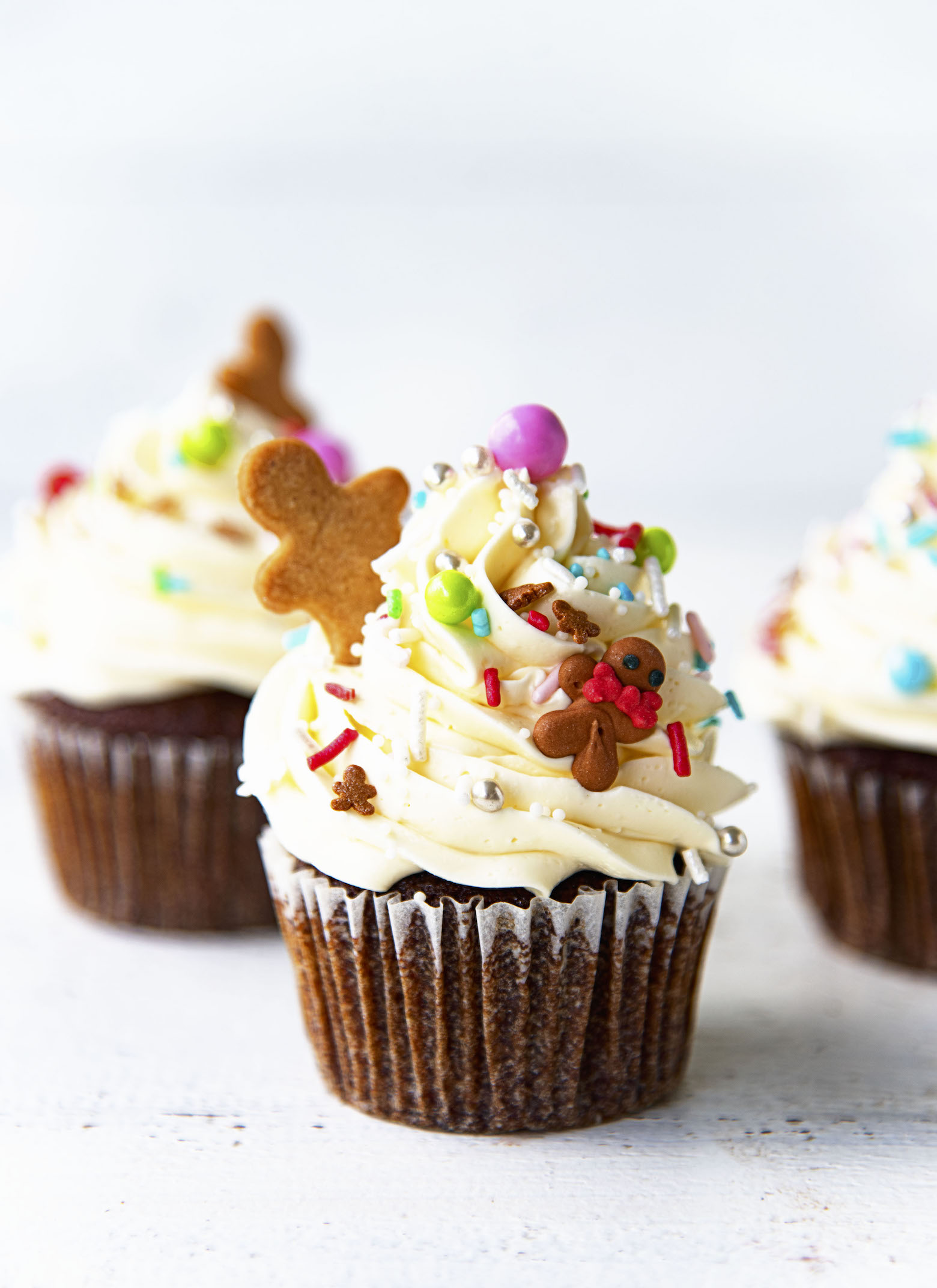 Side view of three cupcakes with focus on the center cupcake.