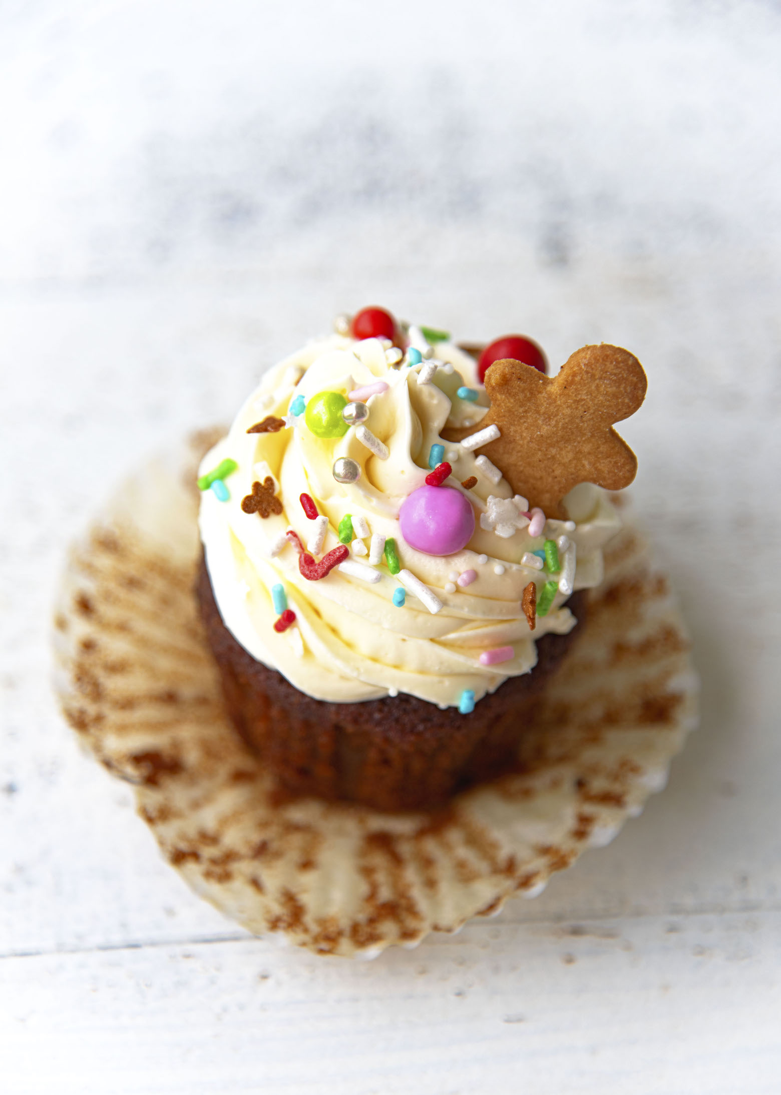 Overhead shot of Gingerbread White Chocolate Cupcake with the cupcake liner pulled away exposing the inside of the cupcake.