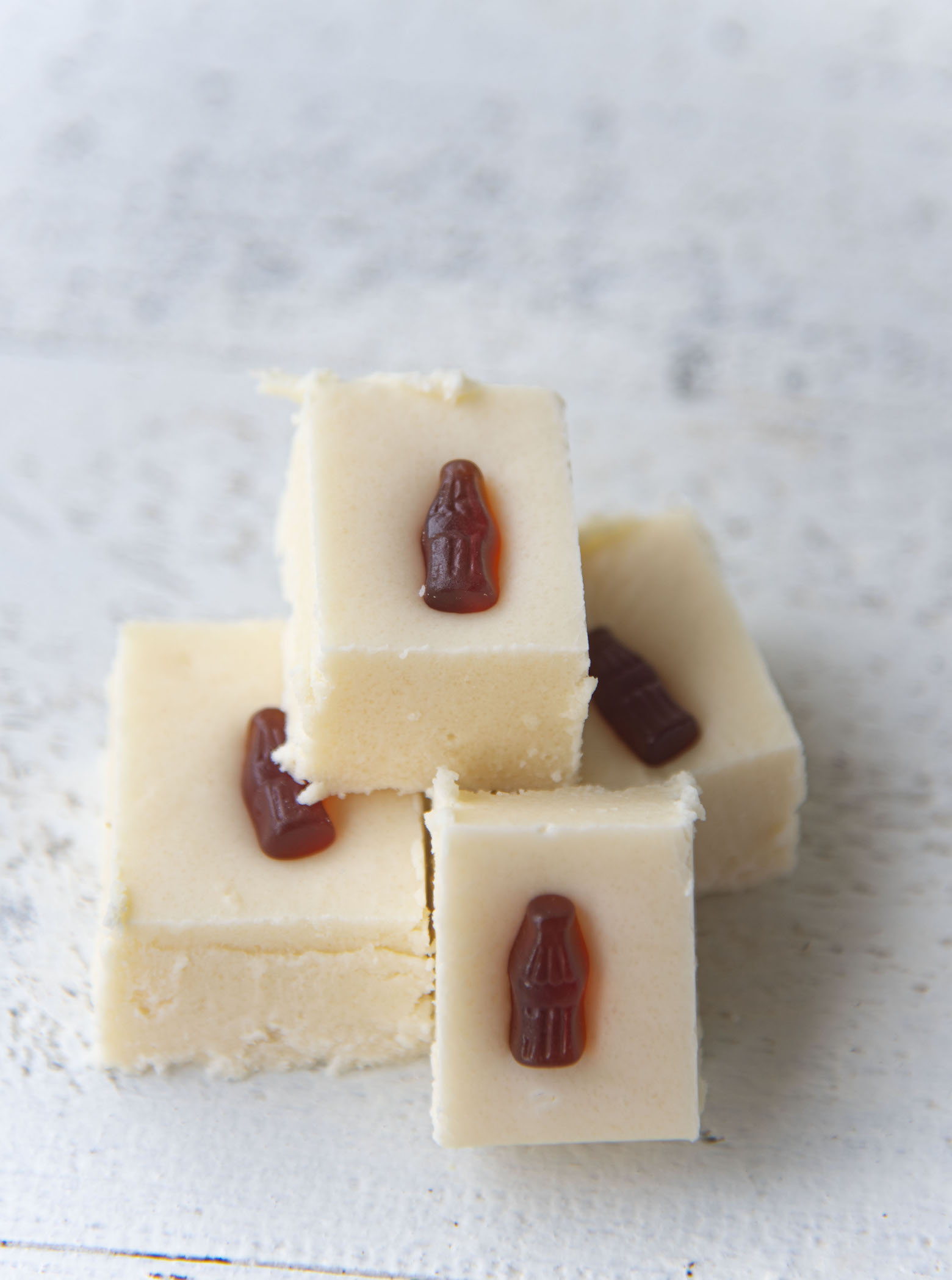 Side view of four pieces of fudge with focus on the top piece of fudge.