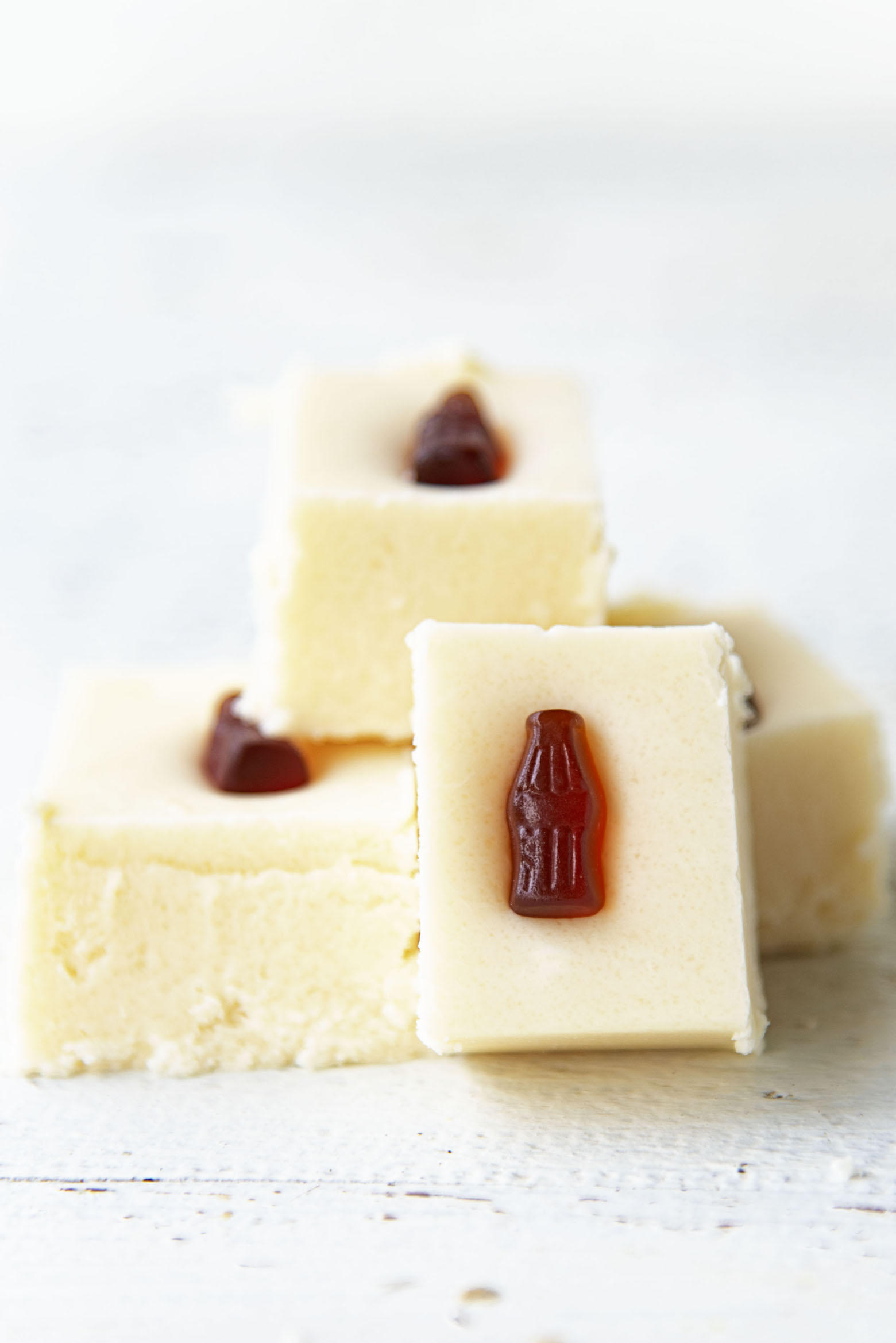 Side view of a couple pieces of Jack and Coke Fudge with the focus on the mini gummy cola.