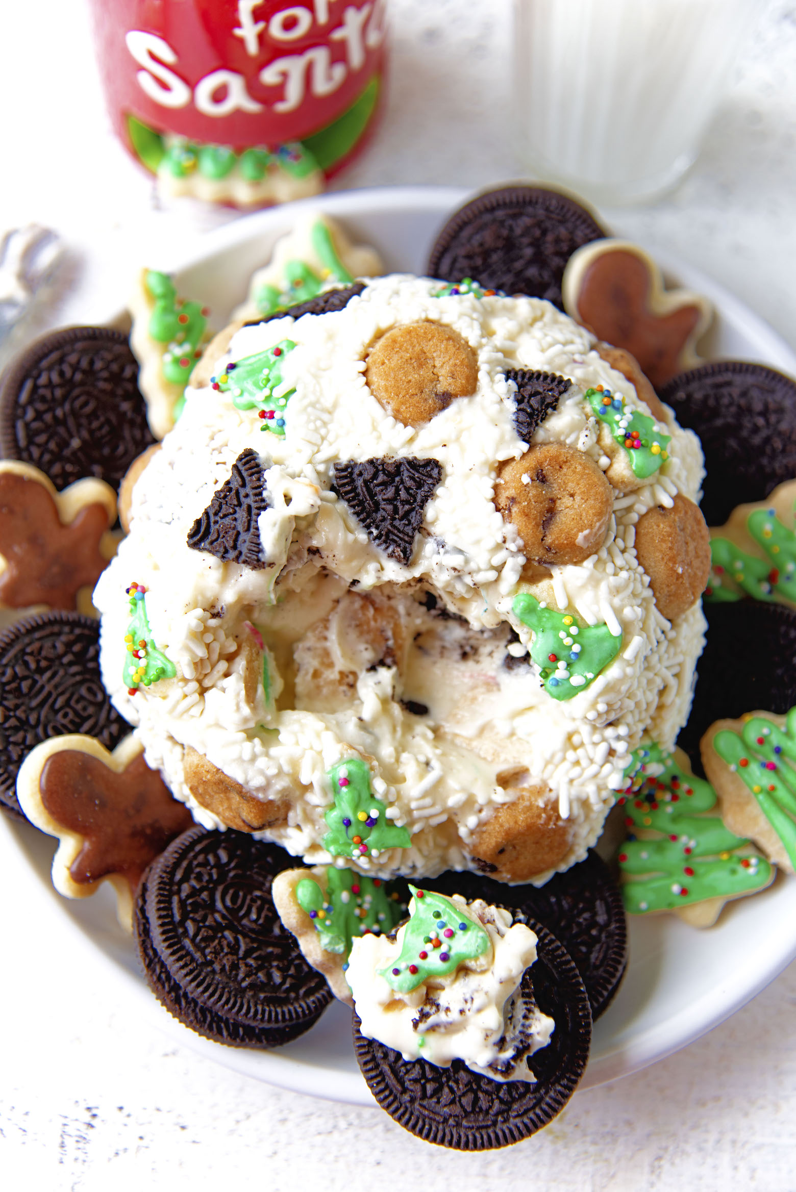 Front view of the cheeseball with part of it missing and spread on a cookie.