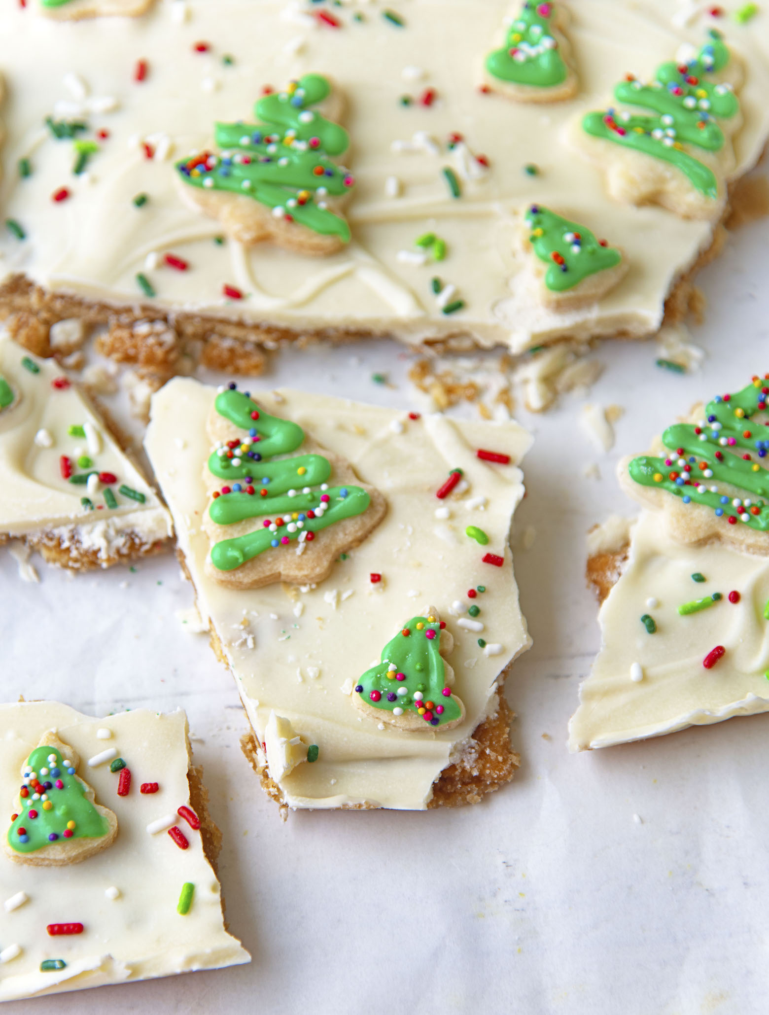 Broken piece of the cracker toffee with focus on the mini sugar cookies.