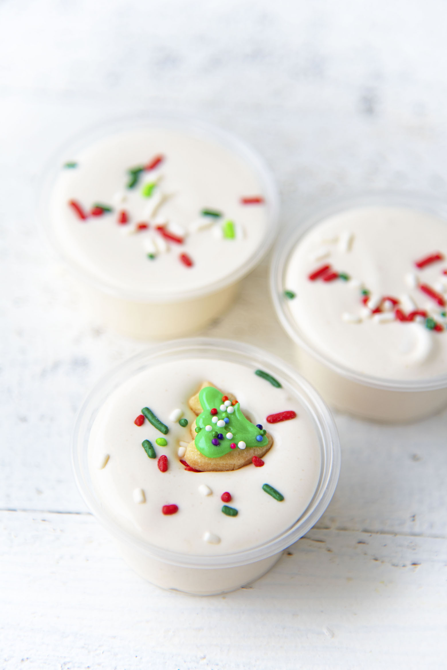 Three quarter shot of Sugar Cookie Pudding Shots with focus on the shot with the mini cookie. 