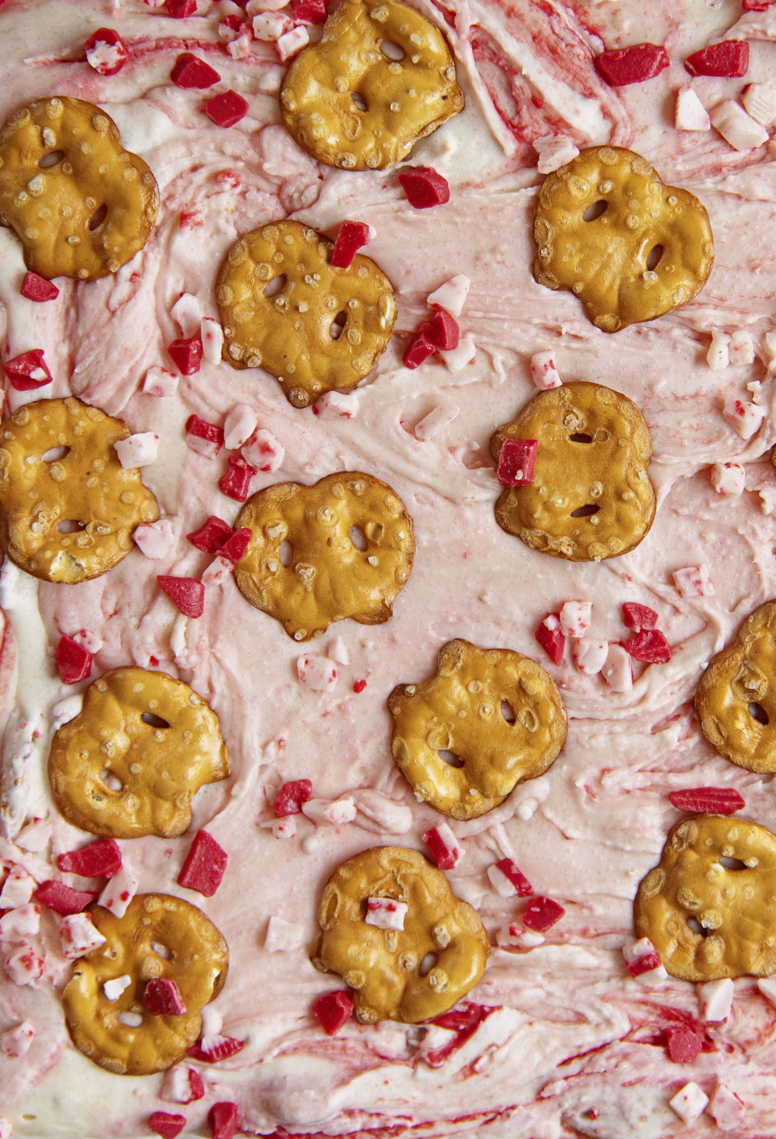 Overhead close up shot of the fudge to highlight the swirl, peppermint chips, and pretzels.