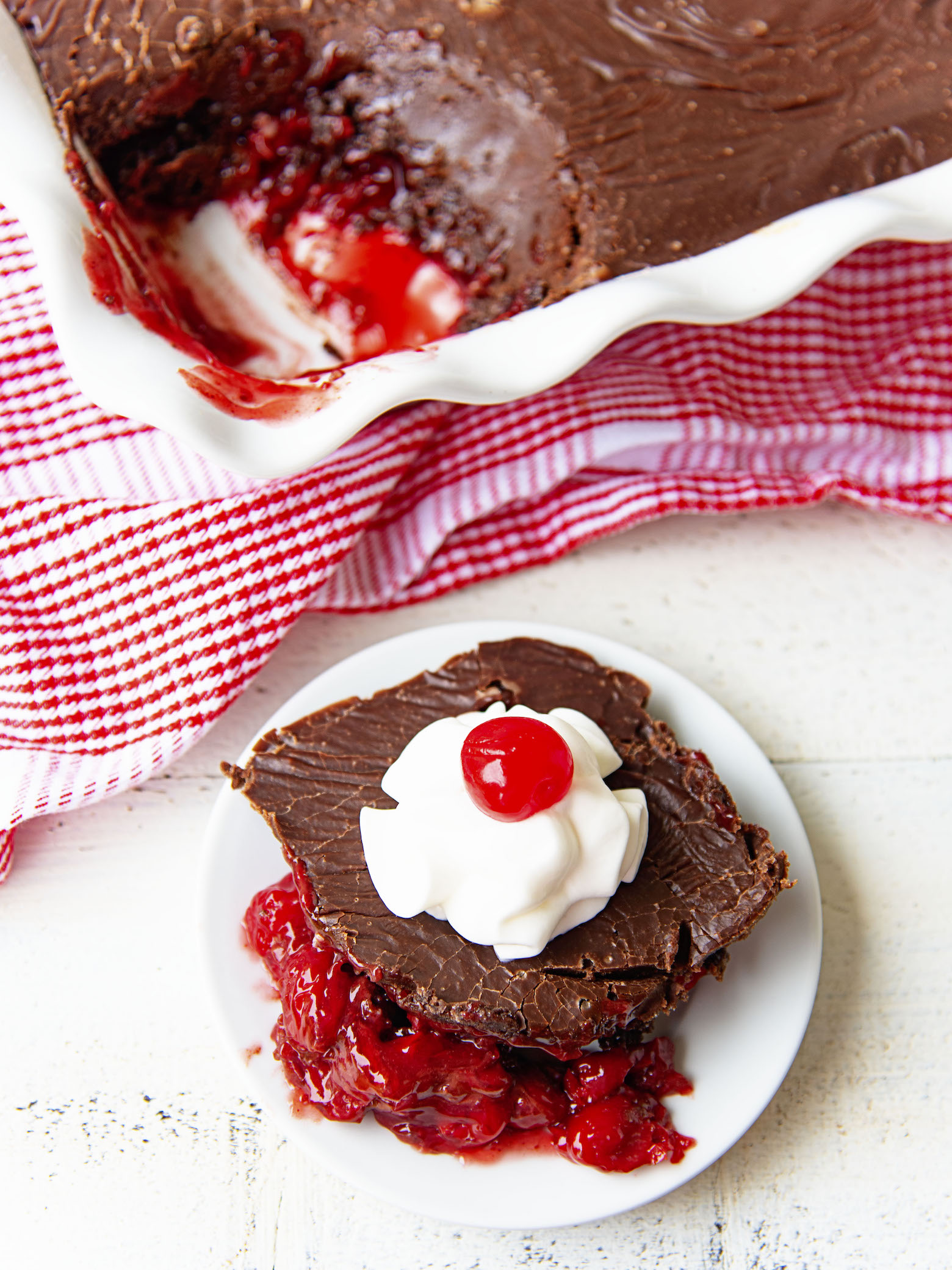 Dr. Pepper Chocolate Dump Cake scoop on a plate with the remaining cake behind it. 