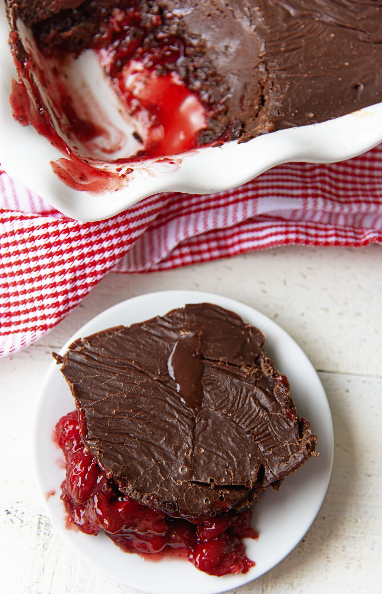 Overhead shot of Dr. Pepper Chocolate Dump Cake on a plate with the remaining cake behind it. 