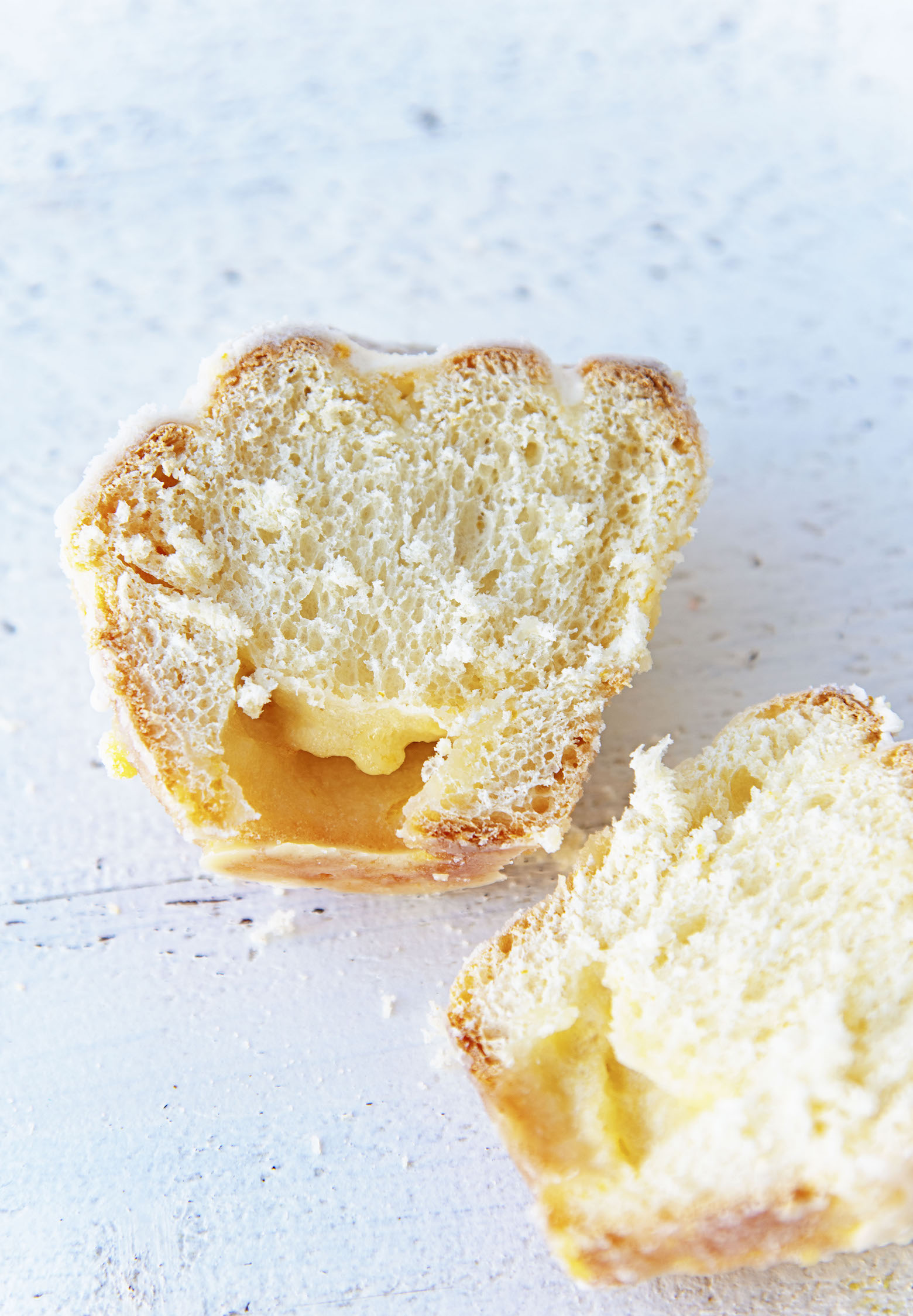 A single Mimosa Sugared Sweet Roll cut in half with the inside exposed. 