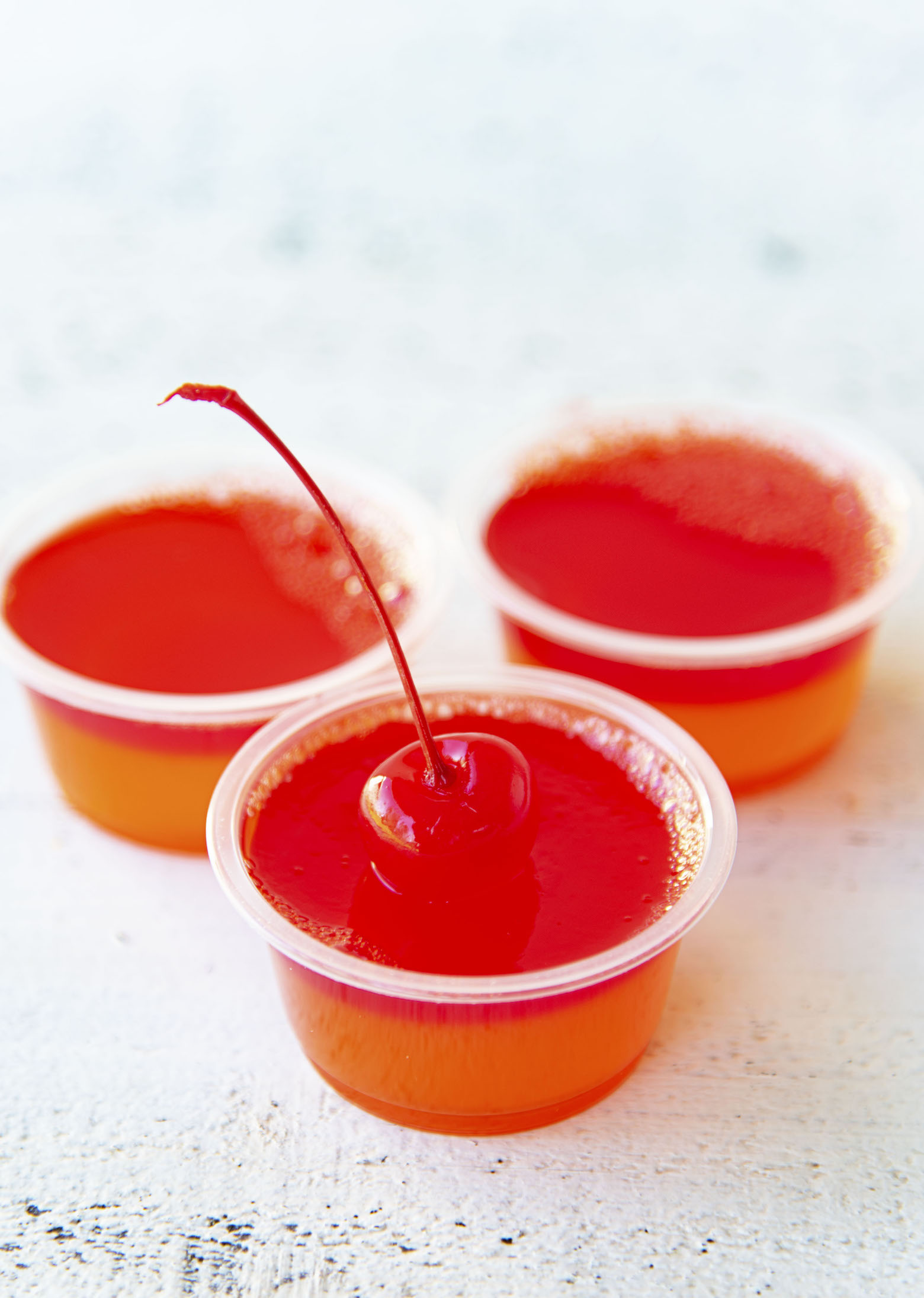 Three Hurricane Cocktail Jello Shots with the first shot being in focus. 