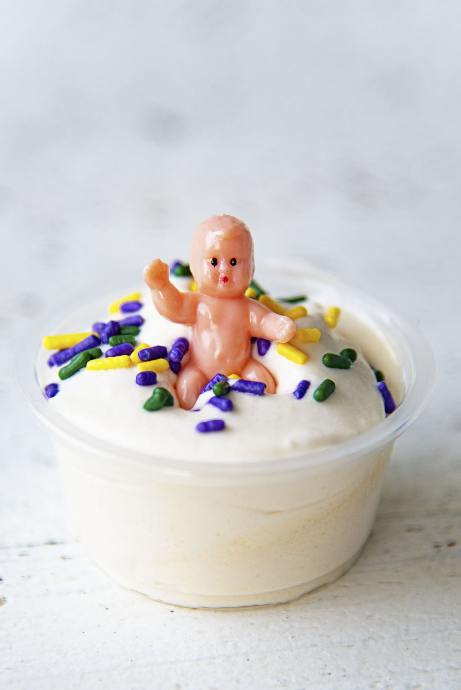 Close up of single King Cake Pudding Shot with the baby on top. 