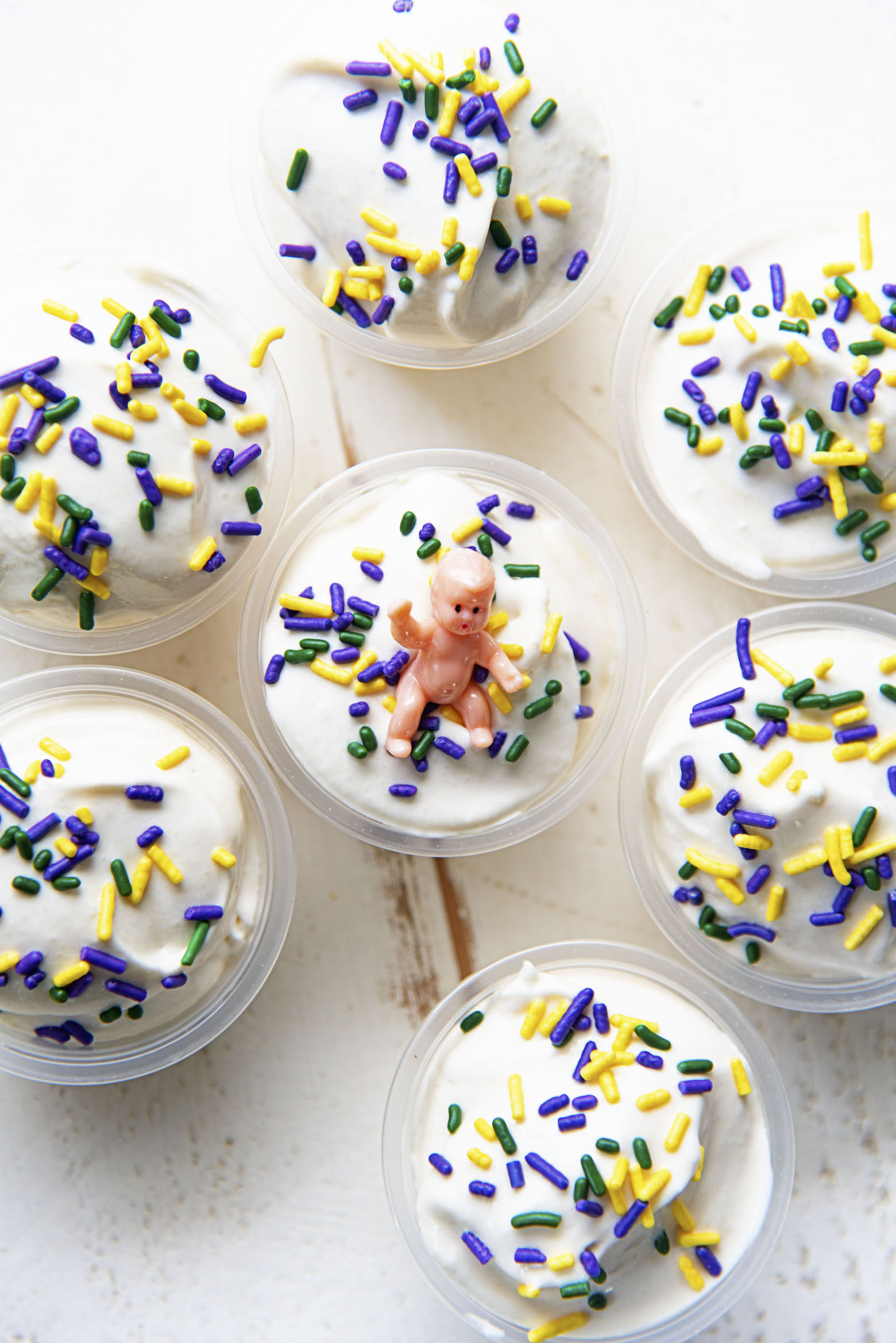 Overhead shot of a grouping of several pudding shots. With the focus on the middle shot with the baby on it. 