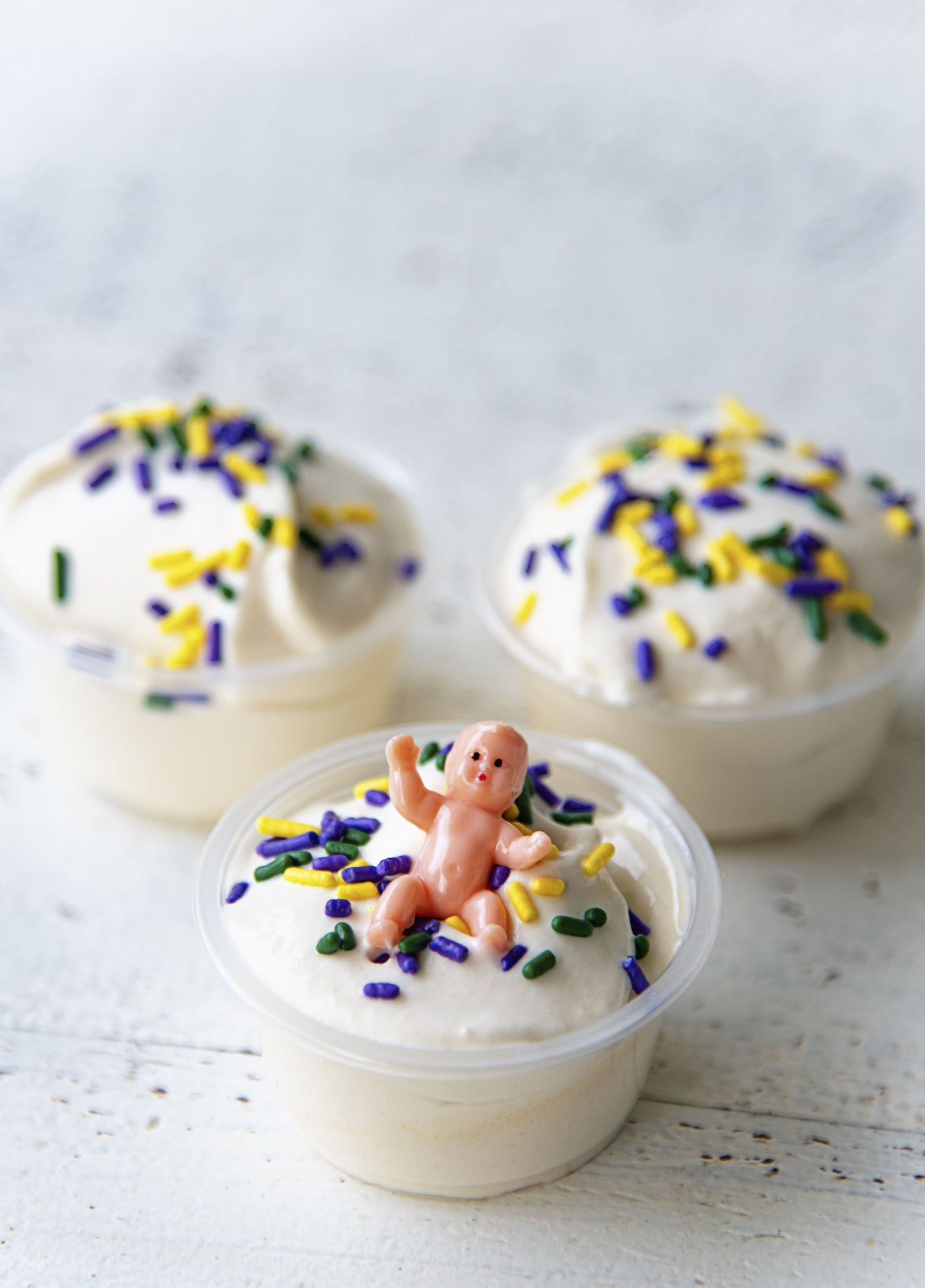 Three King Cake Pudding Shots together with the one with the baby up front. 