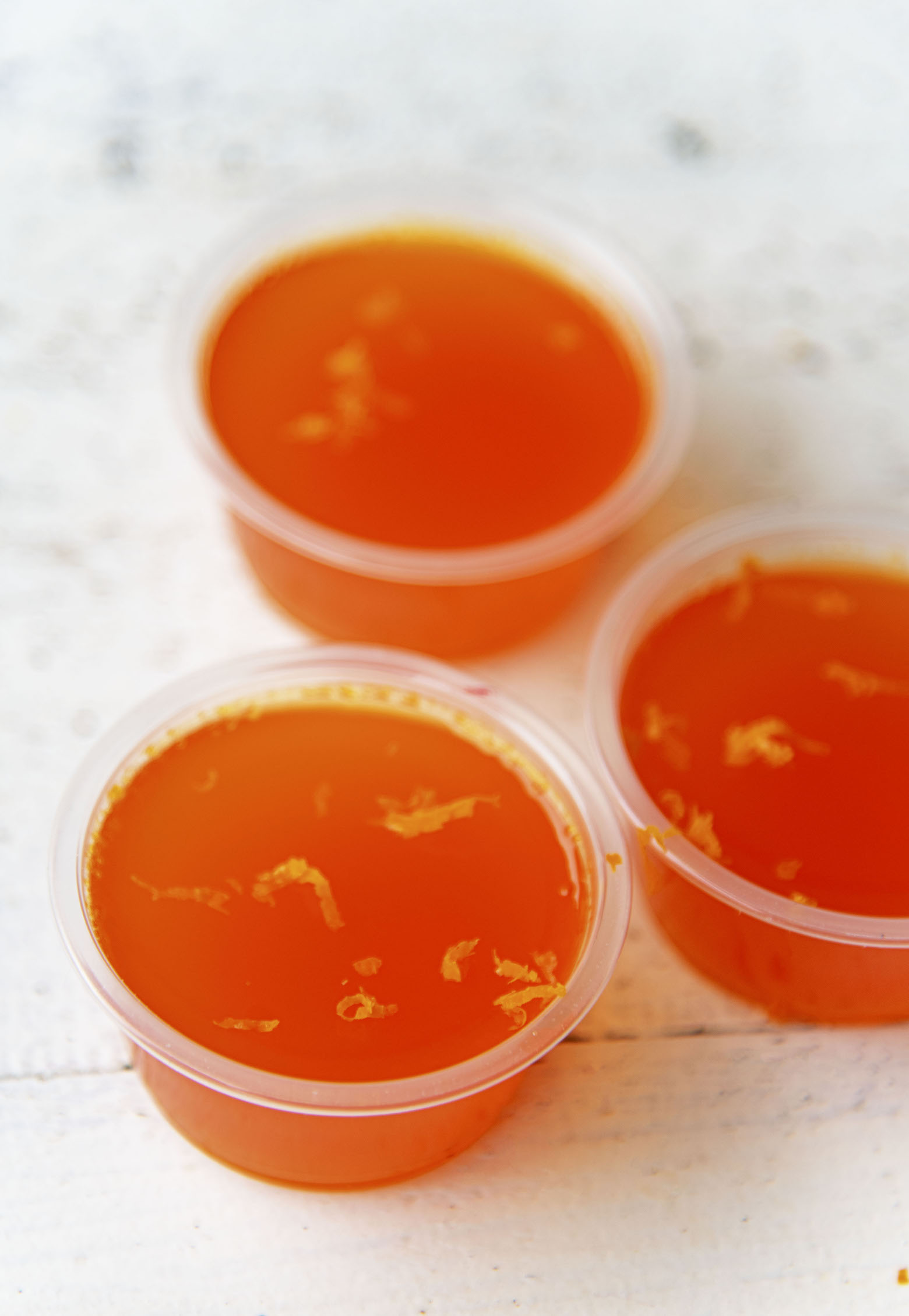 Three Touchdown Red Bull Jello Shots with orange zest on them. 