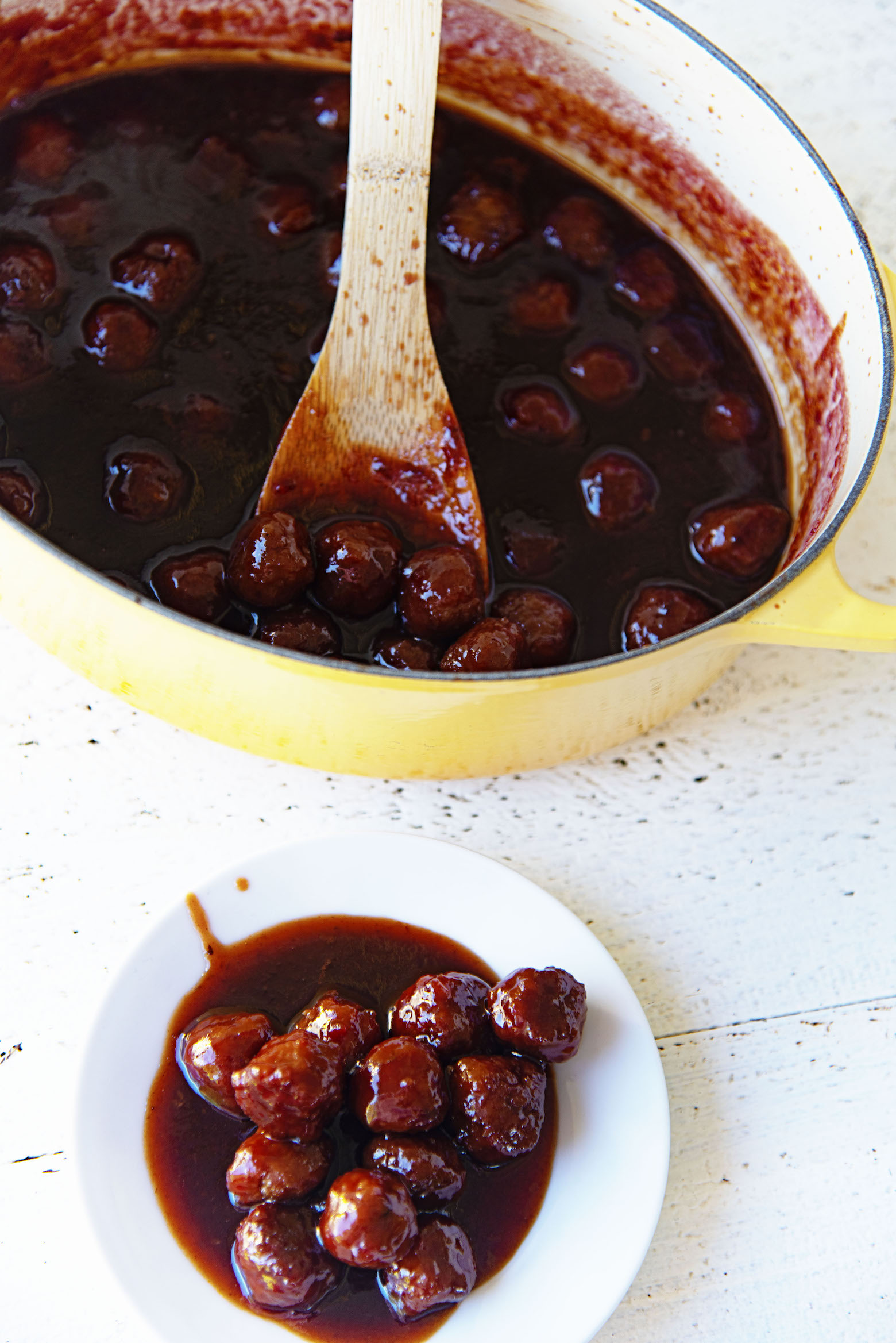 Overhead of Vegetarian Grape Jelly Meatballs on a plate and in the pot. 