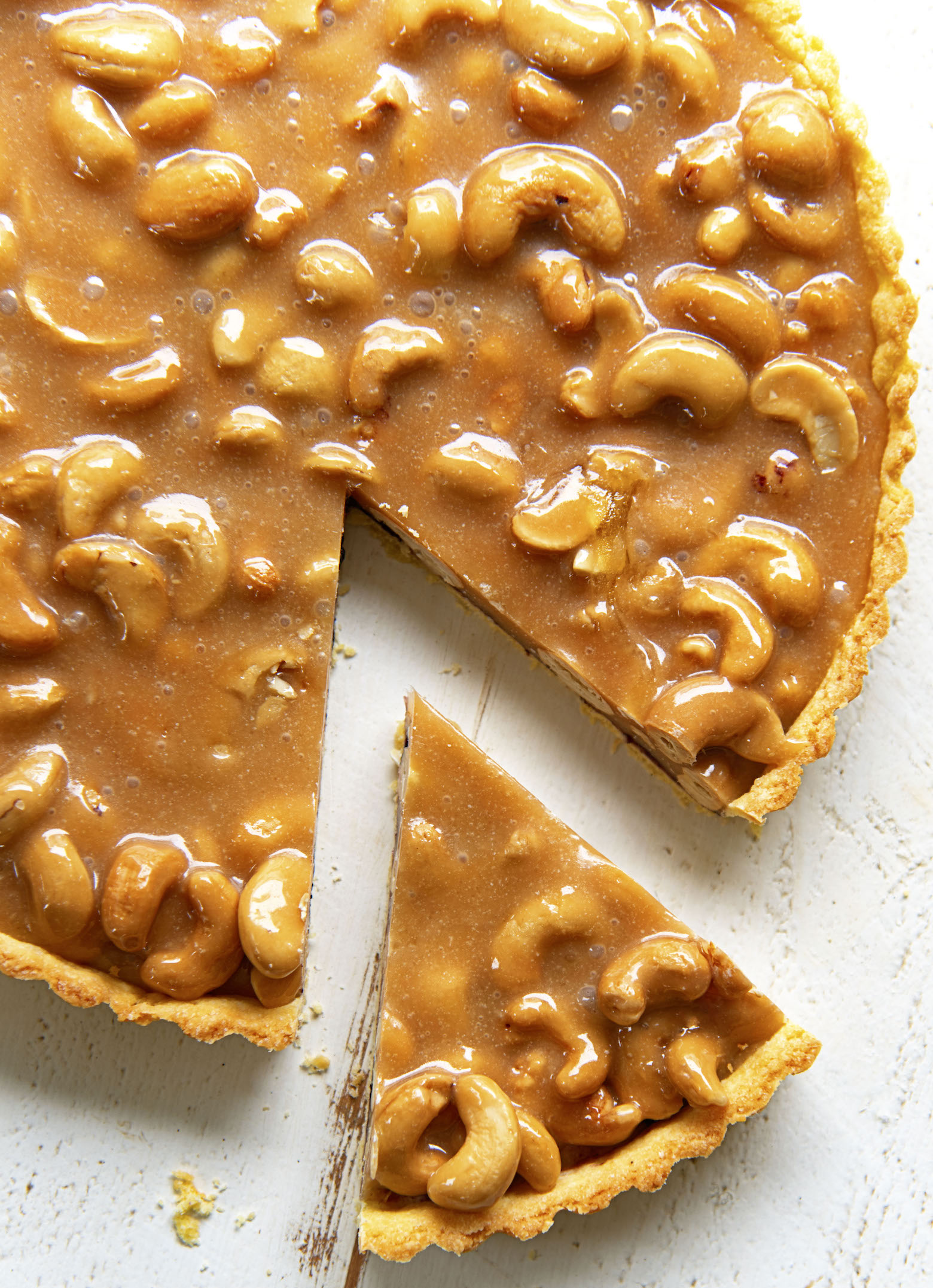 Overhead view of Baseball Nut Caramel Tart with piece cut out. 