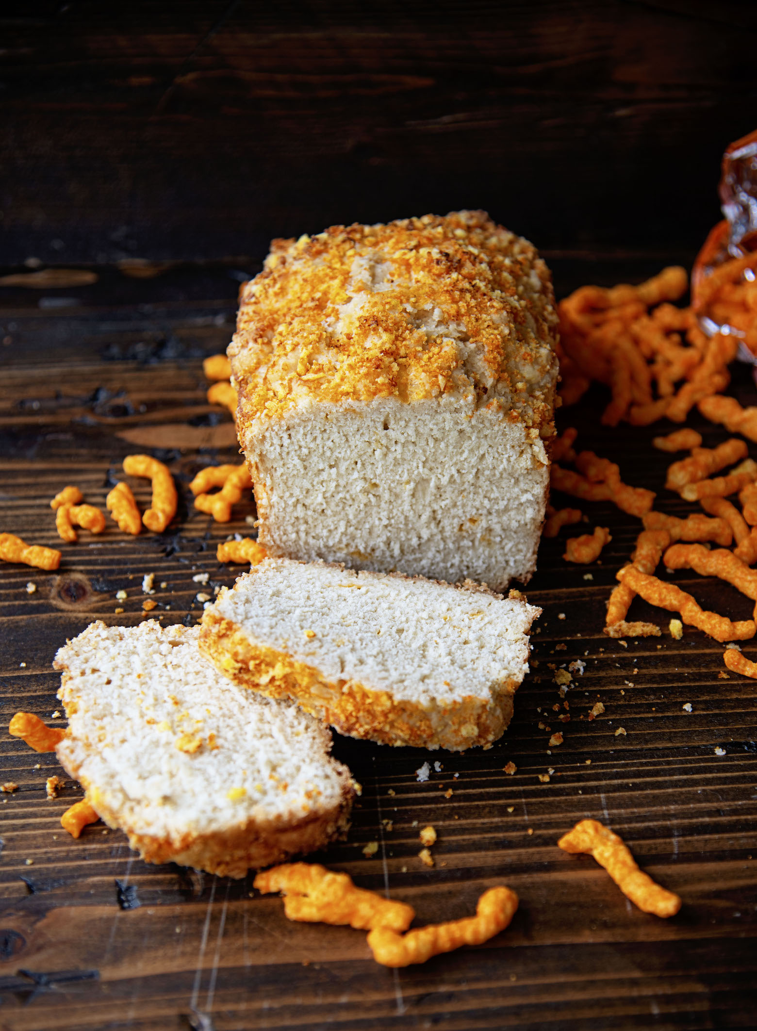 Sliced Cheetos Cheddar Beer Bread  with Cheetos spilled out around it. 