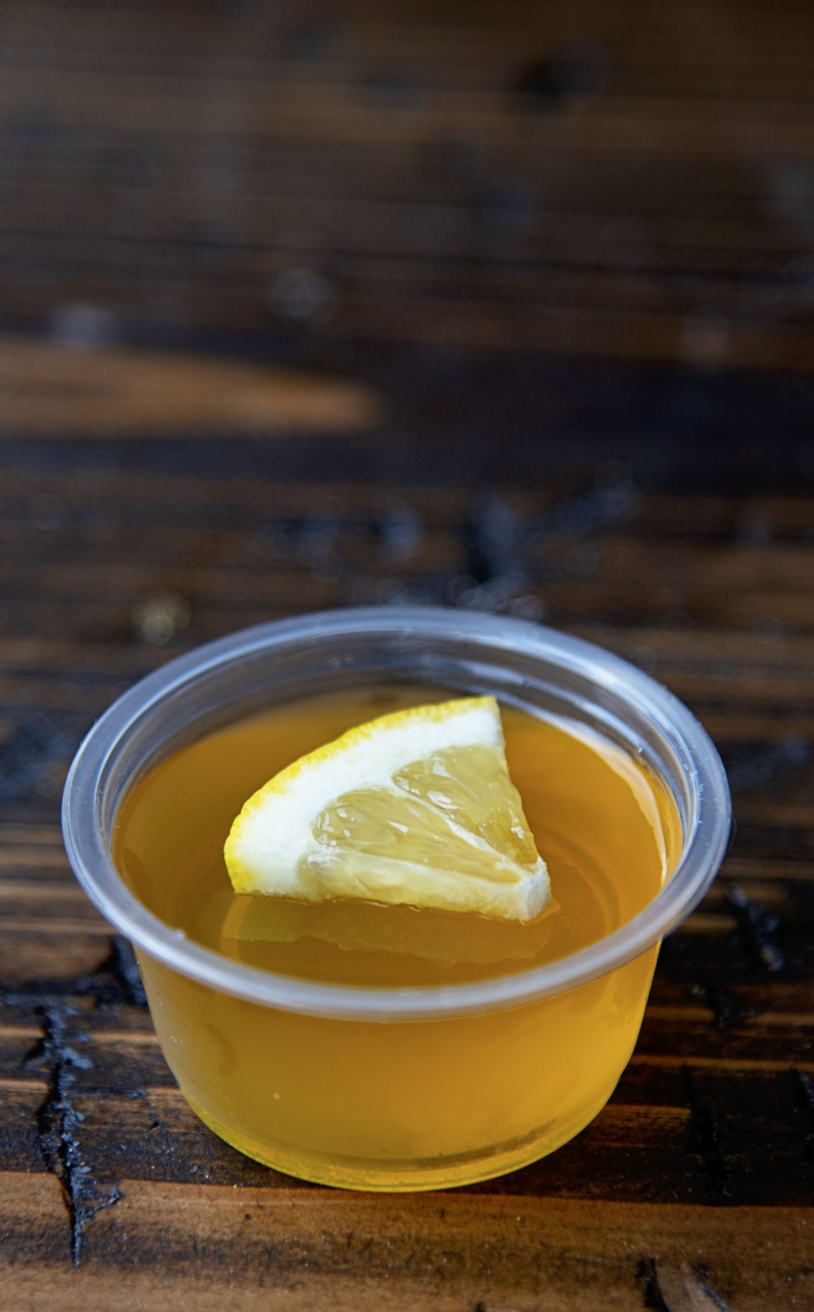 Single Lynchburg Lemonade Jello Shot with lemon wedge on top