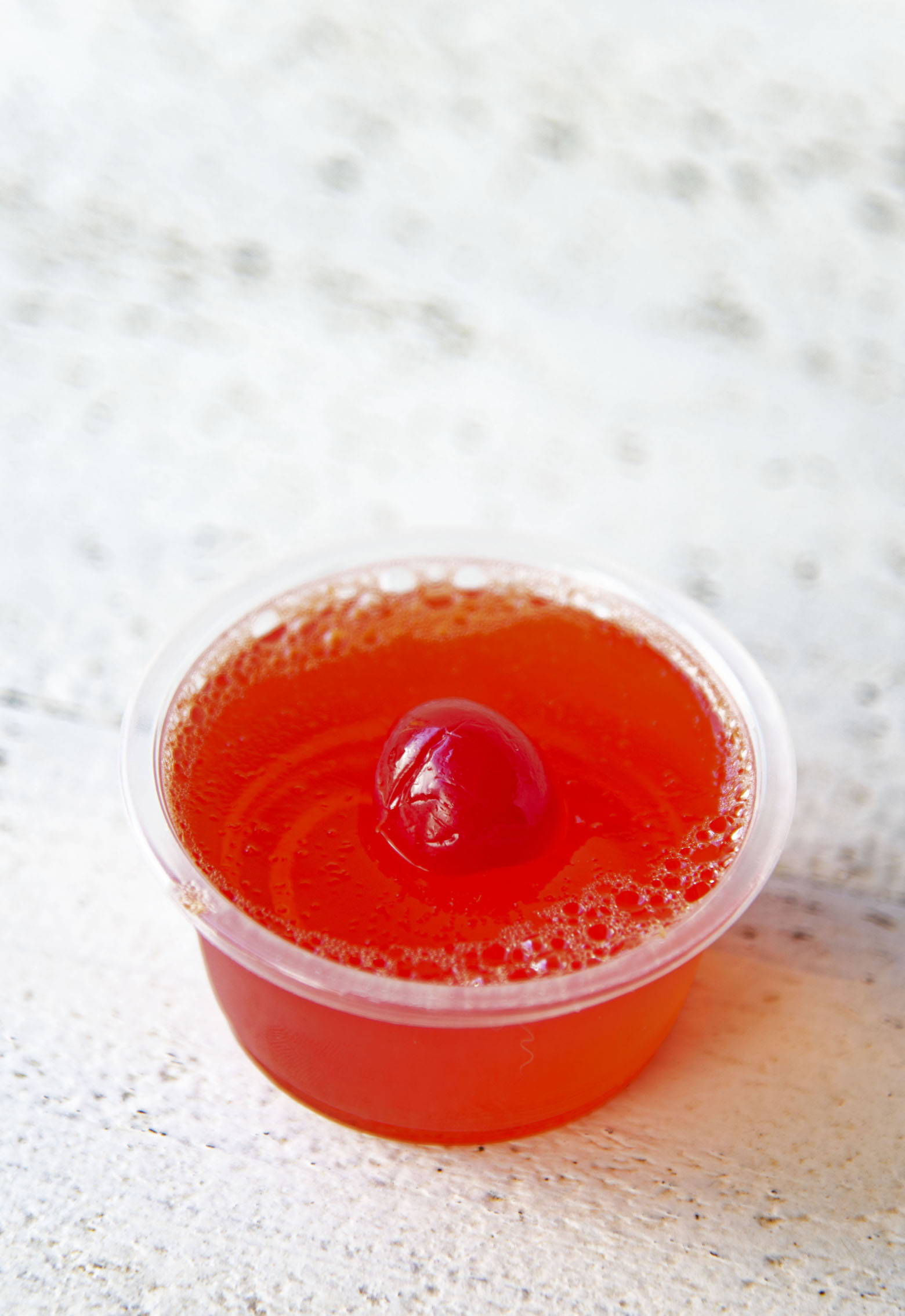 Single Hawaiian Punch Jello Shot with cherry on top