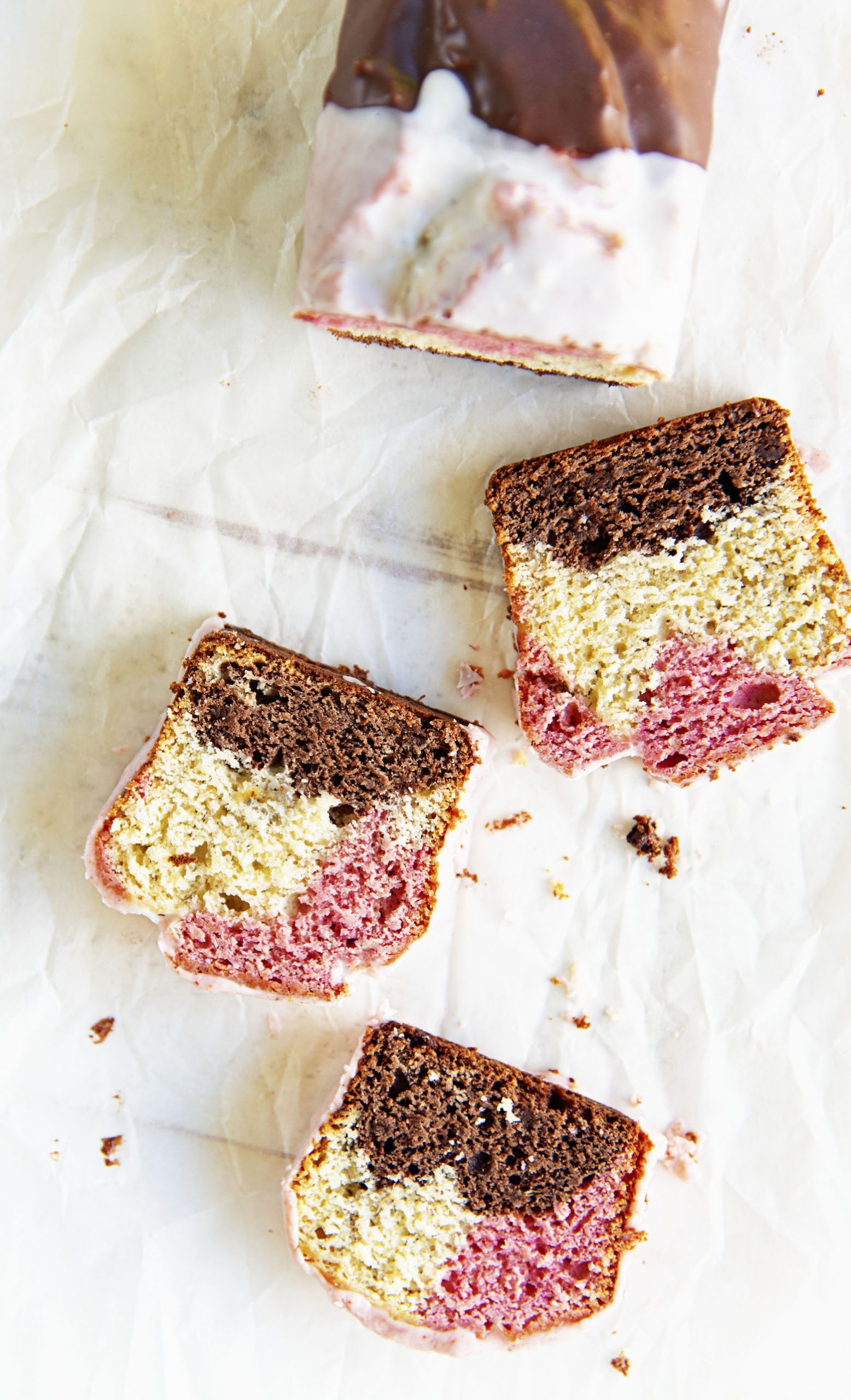 Overhead shot of loaf with three pieces cut and scattered out in front. 