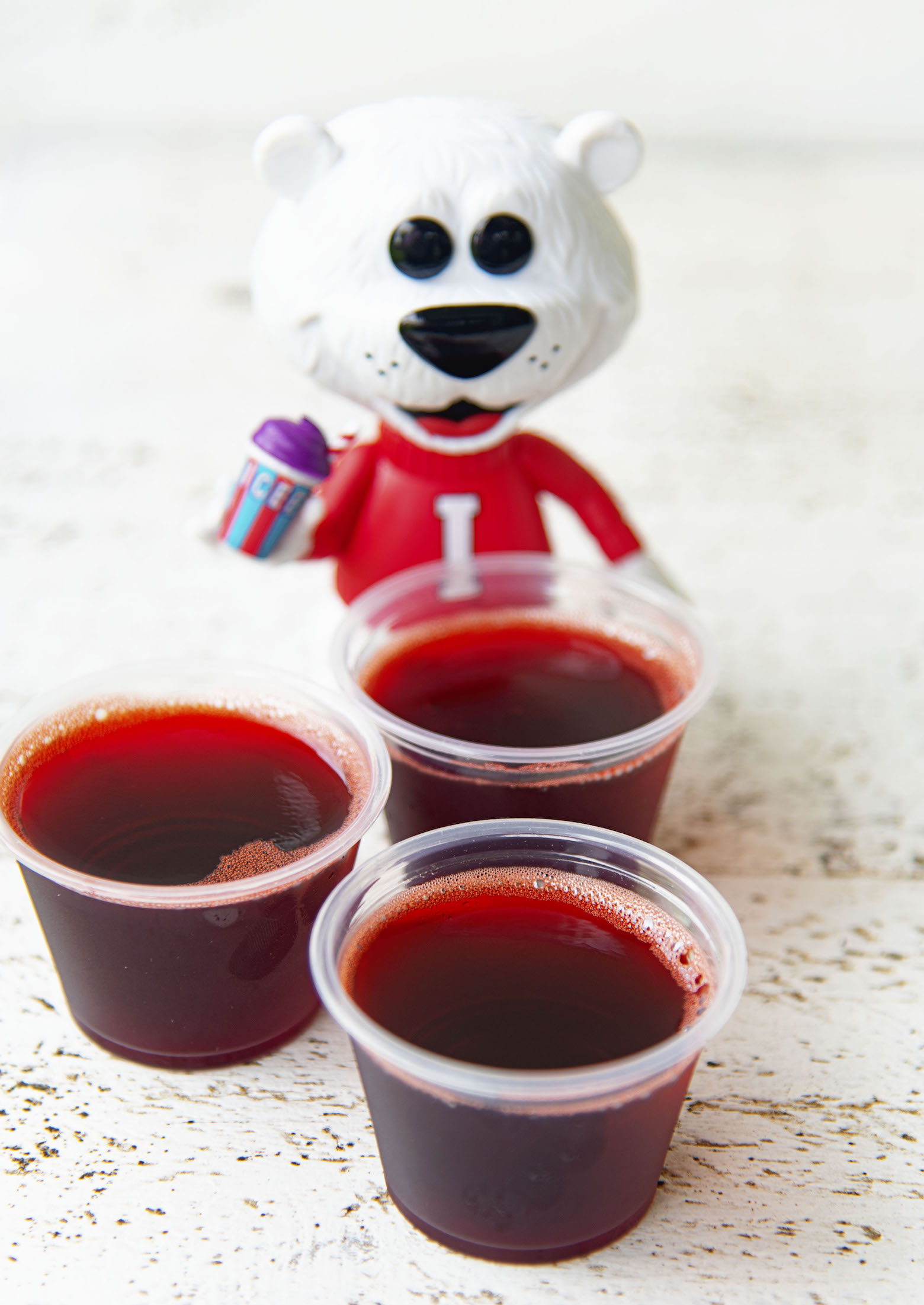 Grouping of three Cherry Cola Icee Jello Shots with the Icee Bear