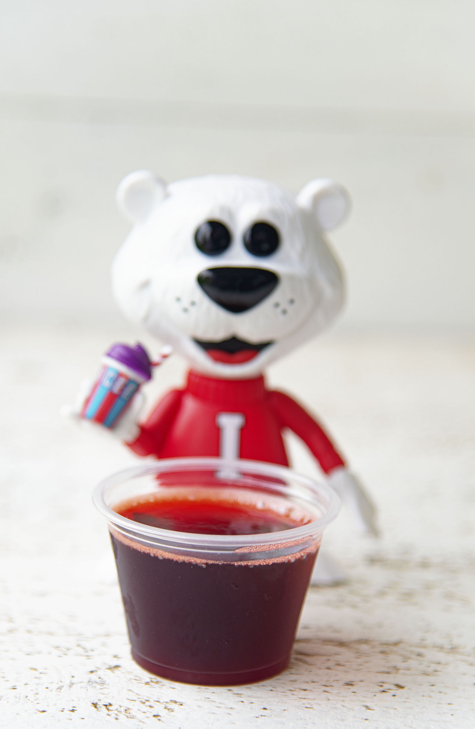 Single Cherry Cola Icee Jello Shots with Icee Bear in background