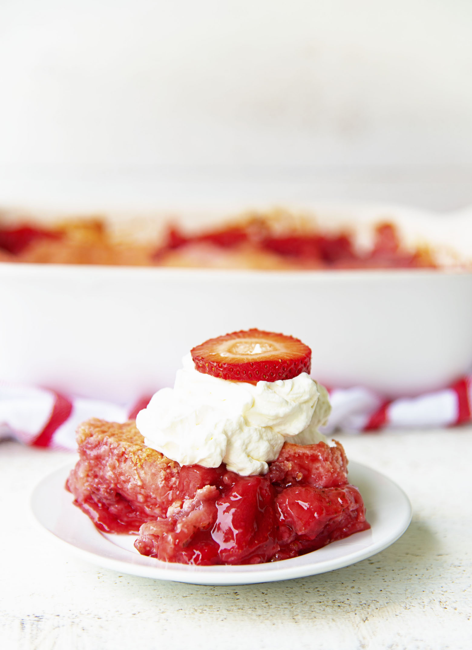 Side view of a scoop of Strawberry Shortcake Dump Cake on a plate.