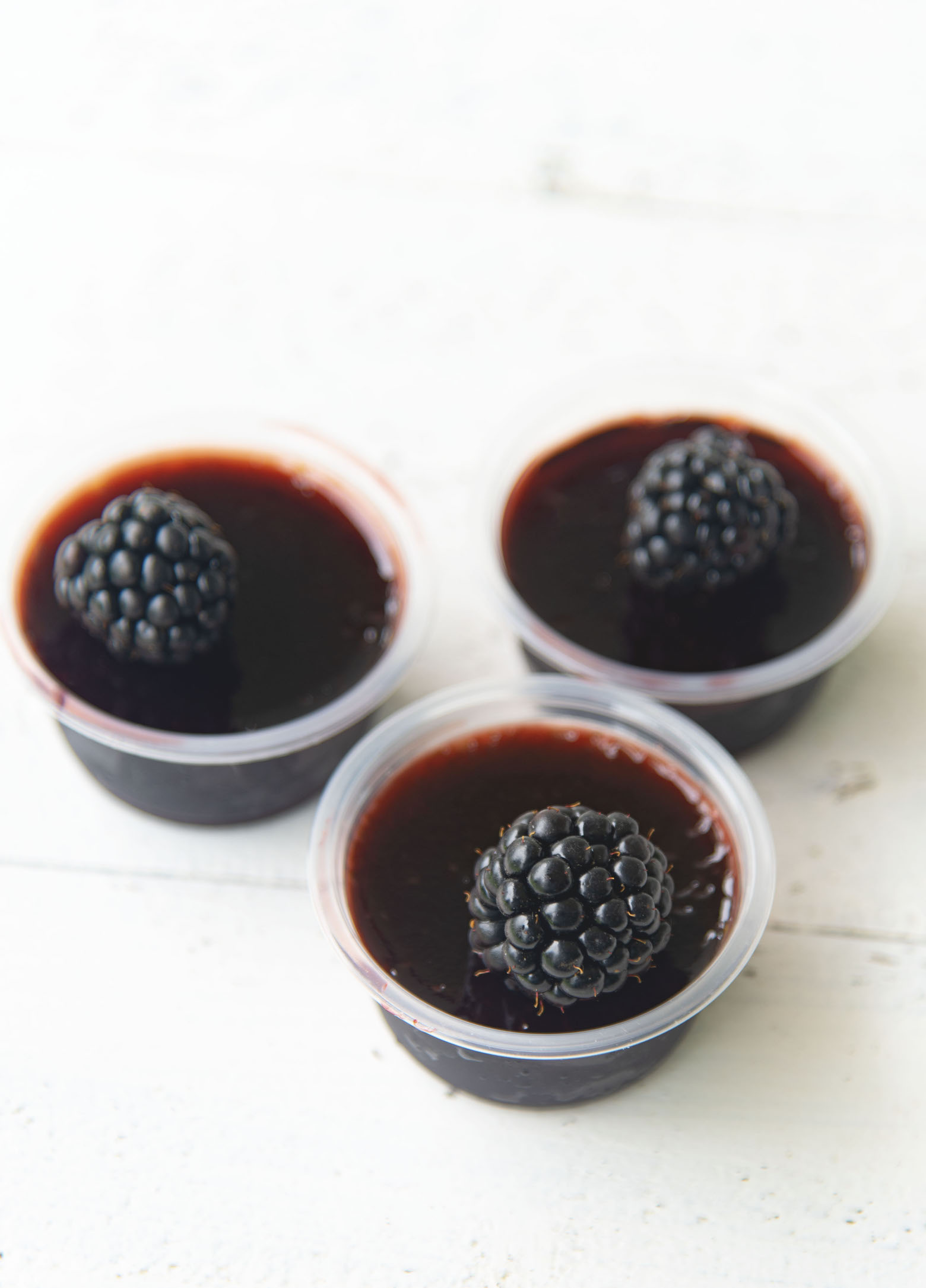 Three Blackberry Bourbon Jello Shots clustered together