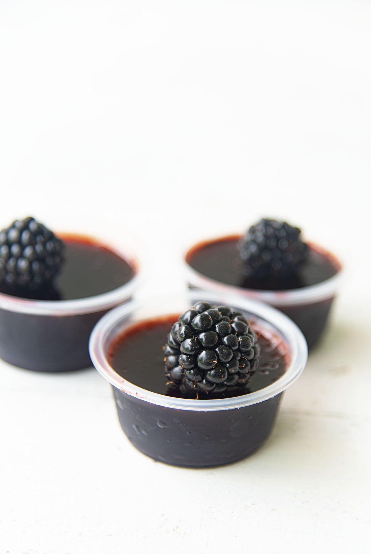 Side view of three Blackberry Bourbon Jello Shots 