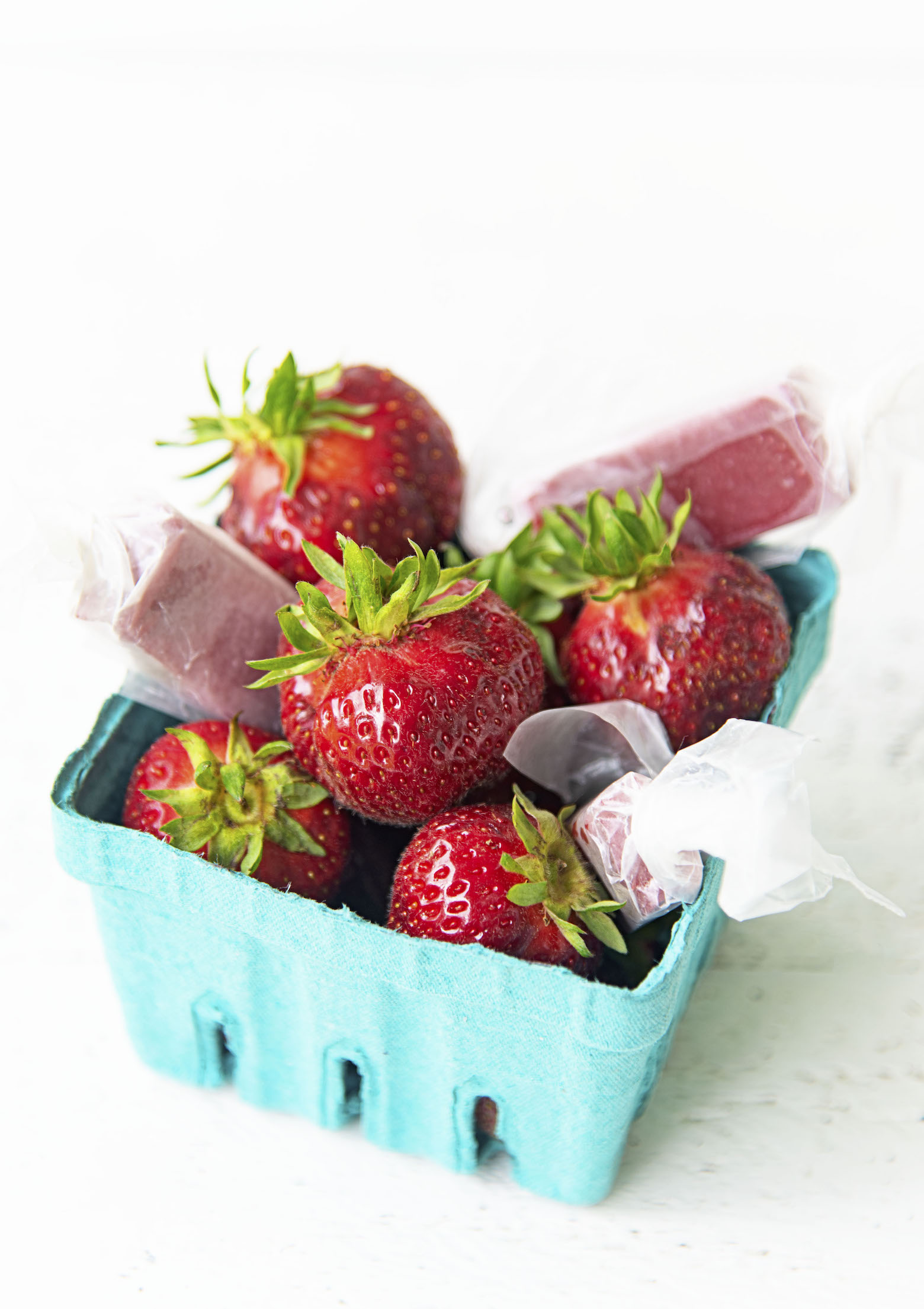 Up close shot of berries and caramels in a basket. 