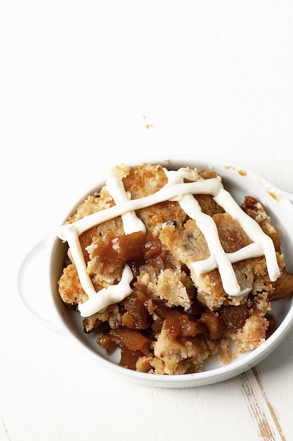 Apple Cinnamon Bun Cookie Cobbler in a bowl with cream cheese frosting. 