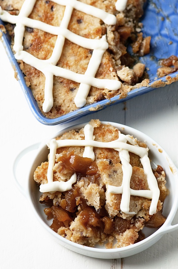 Overhead shot of Apple Cinnamon Bun Cookie Cobbler on a plate with remaining cobbler to the side. 