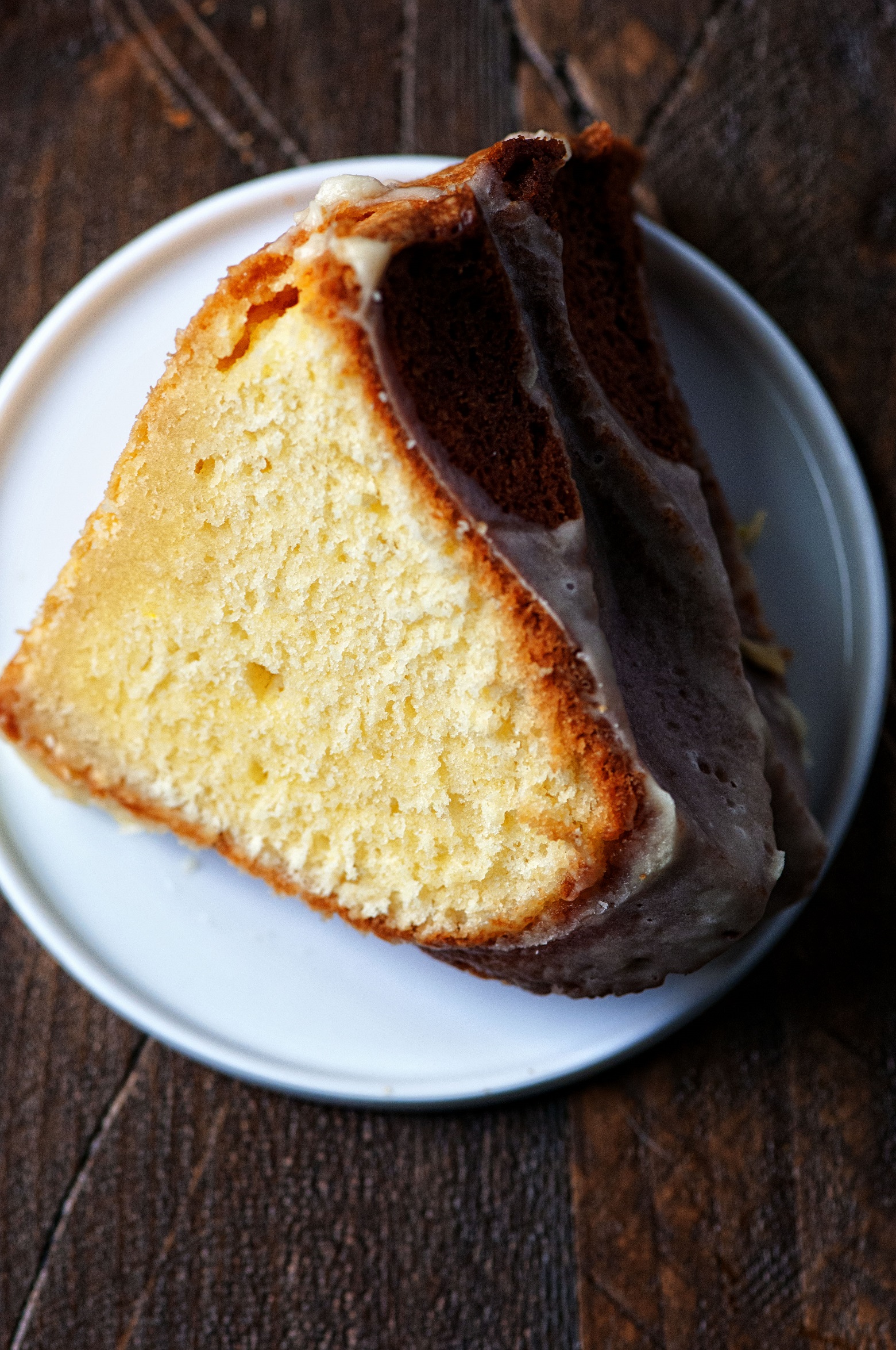 Slice of pound cake sitting on a small white plate. 