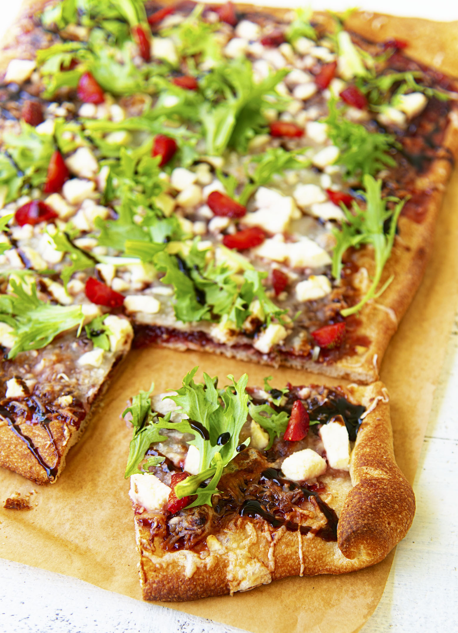 Close up of a piece of Strawberry Balsamic Jam Flatbread cut out of the flatbread. 