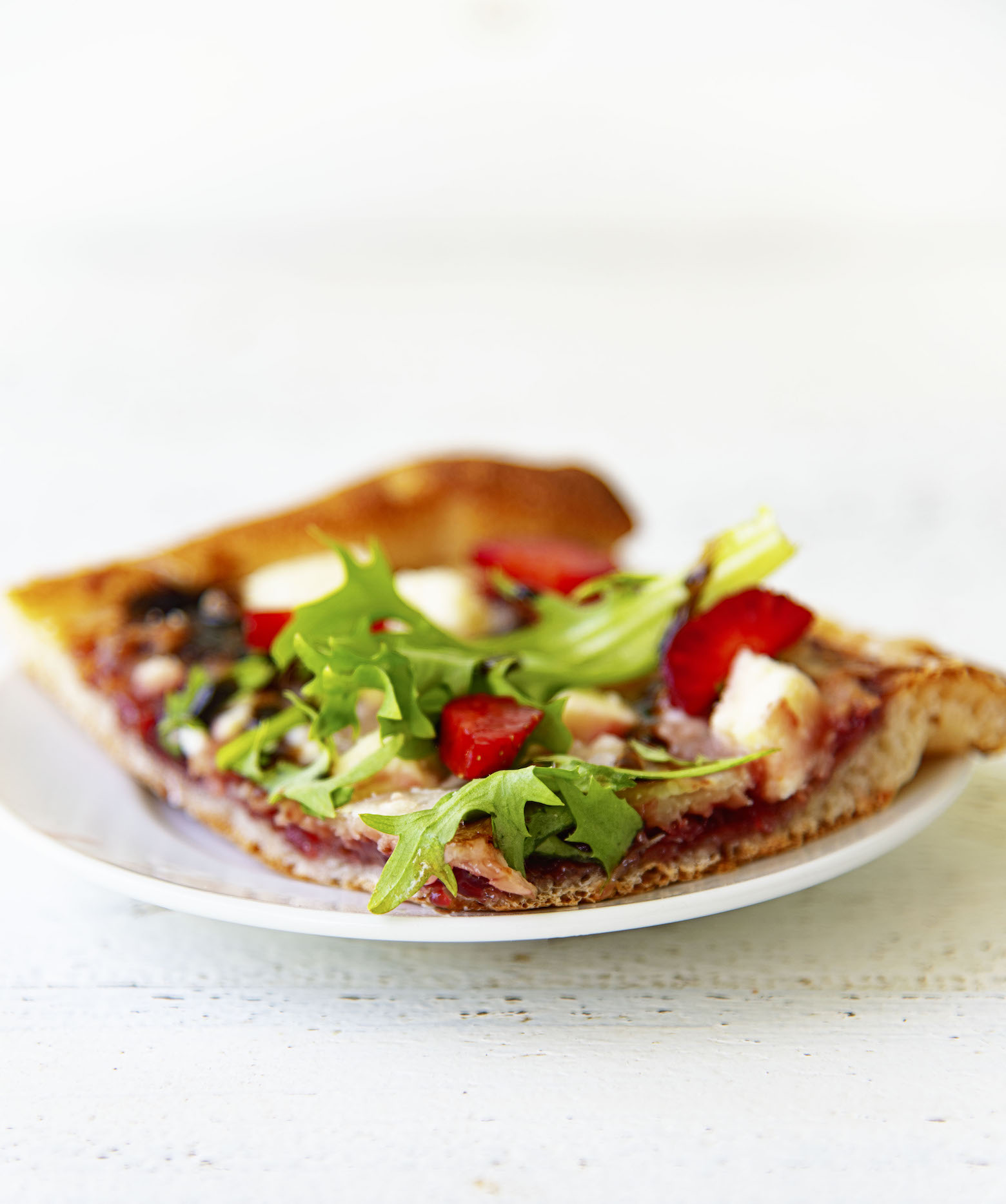 Upclose shot of the flatbread with a close up on the arugula. 