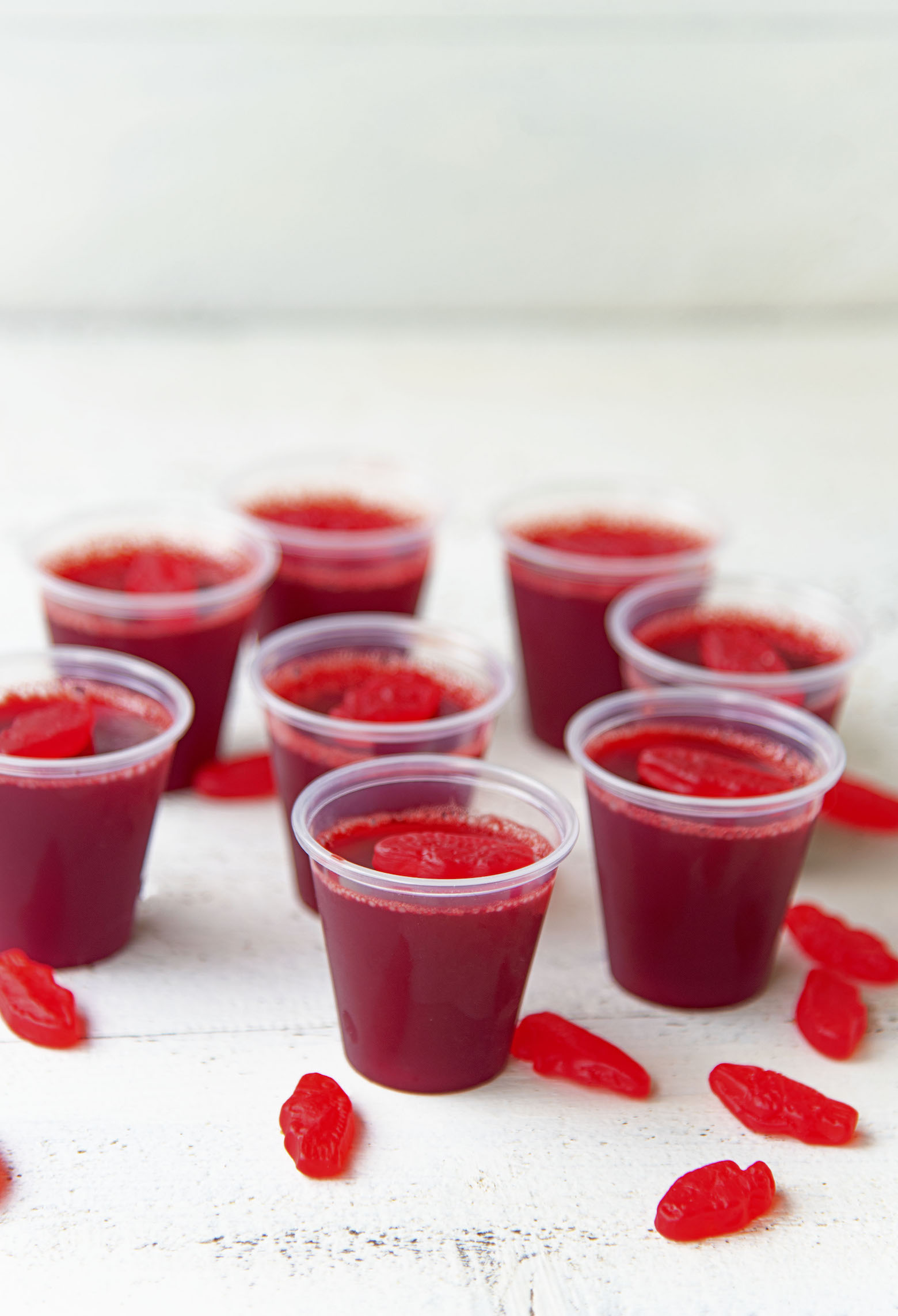 Side view of cluster of jello shots with Swedish fish around them. 