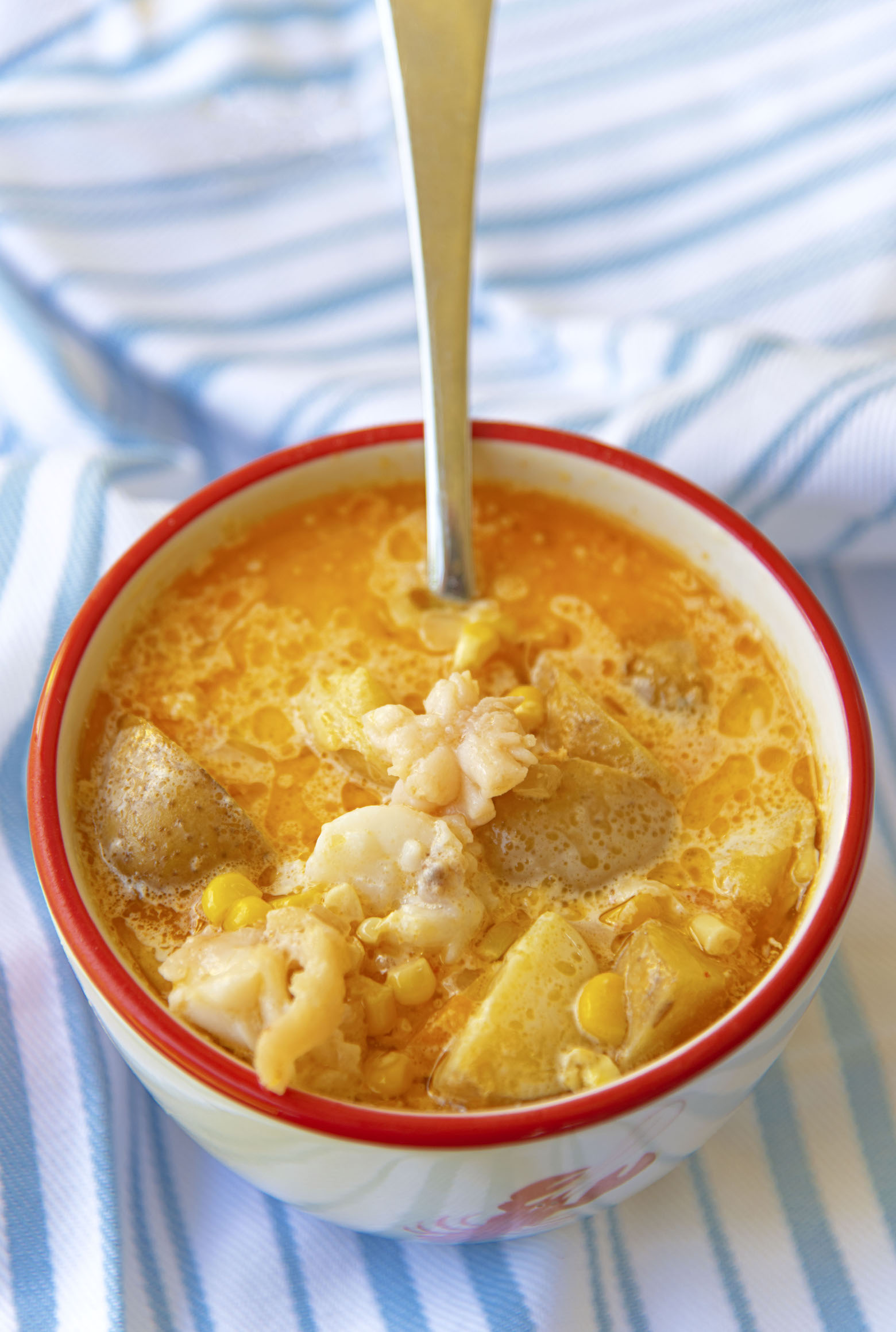 Bowl of Lobster Sweet Corn Chowder with spoon in it. 