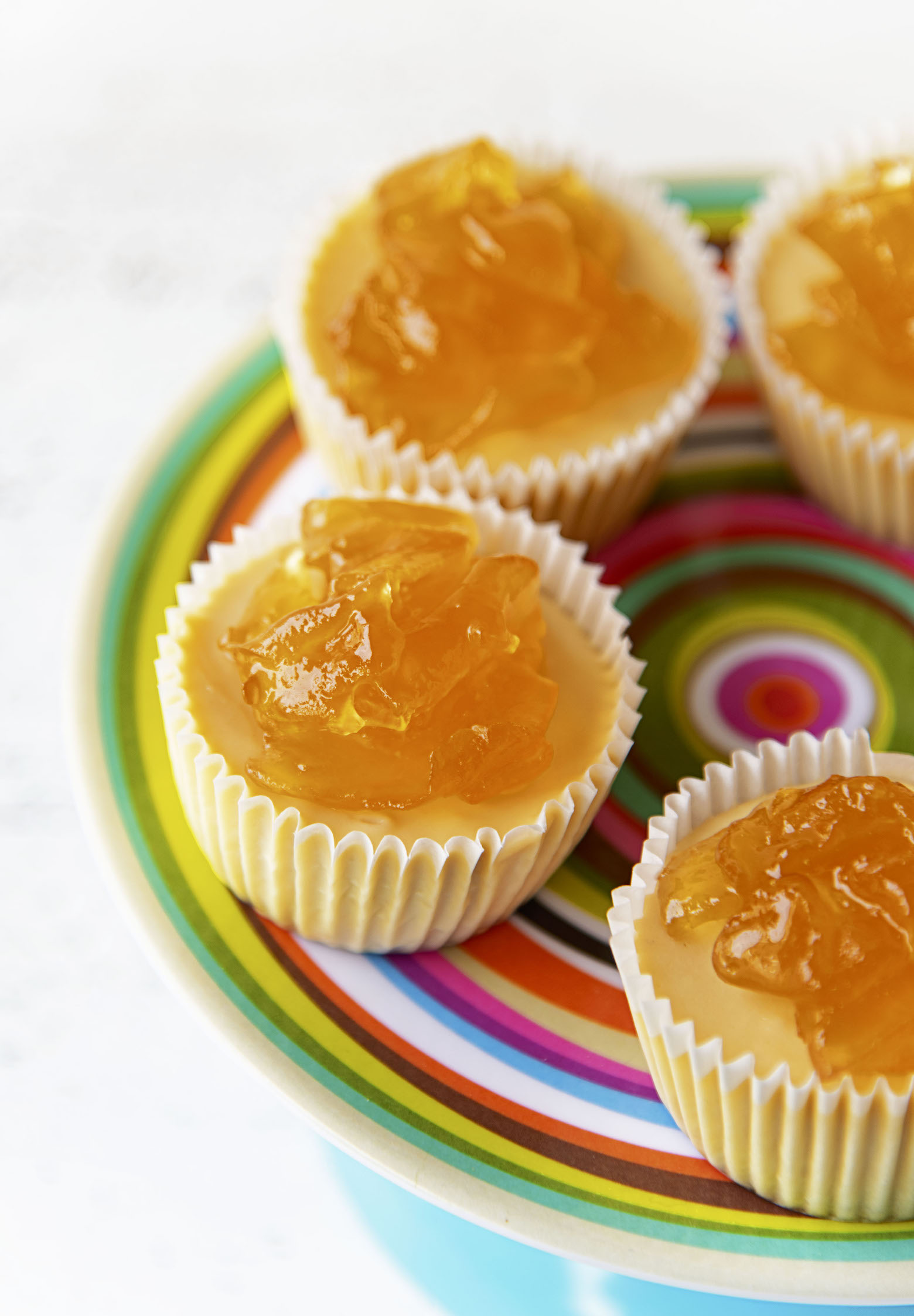 Several Apple Whiskey Cheesecake Bites on a colorful cake plate. 