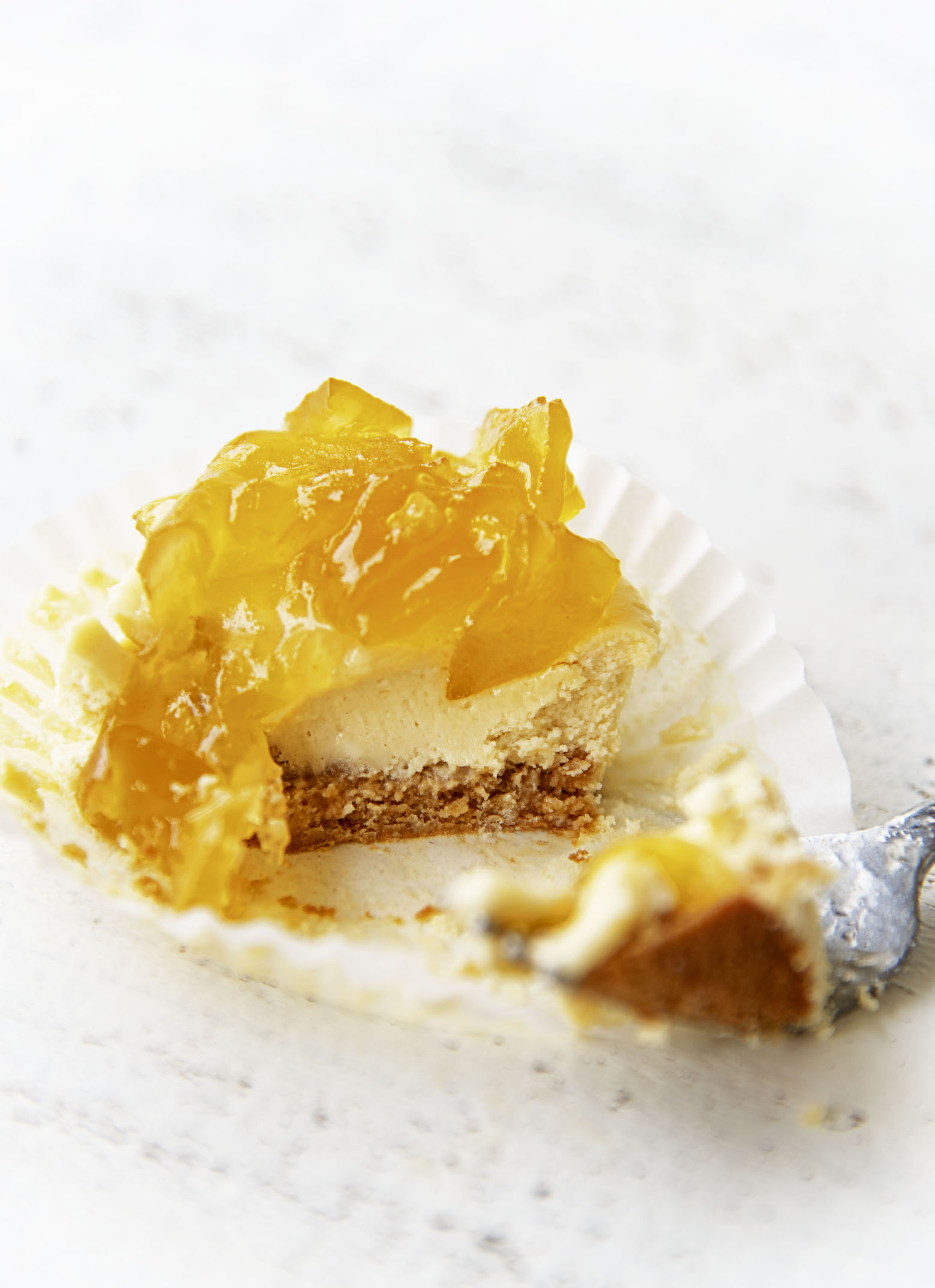 A single Apple Whiskey Cheesecake Bite with a fork through it to show the inside.