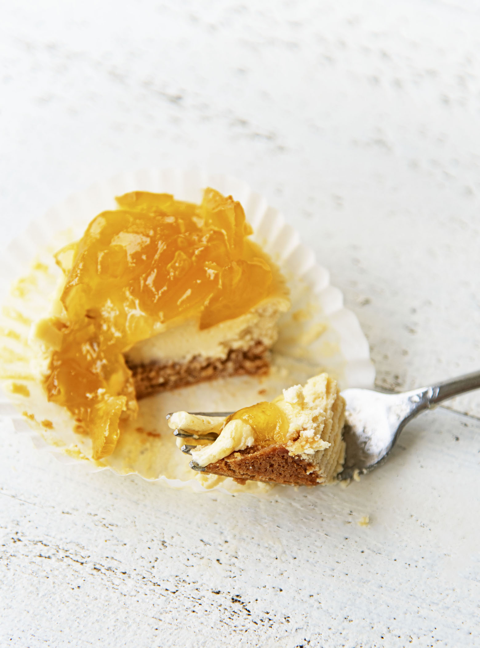 Three quarter shot of a Apple Whiskey Cheesecake Bite with a fork going through it.