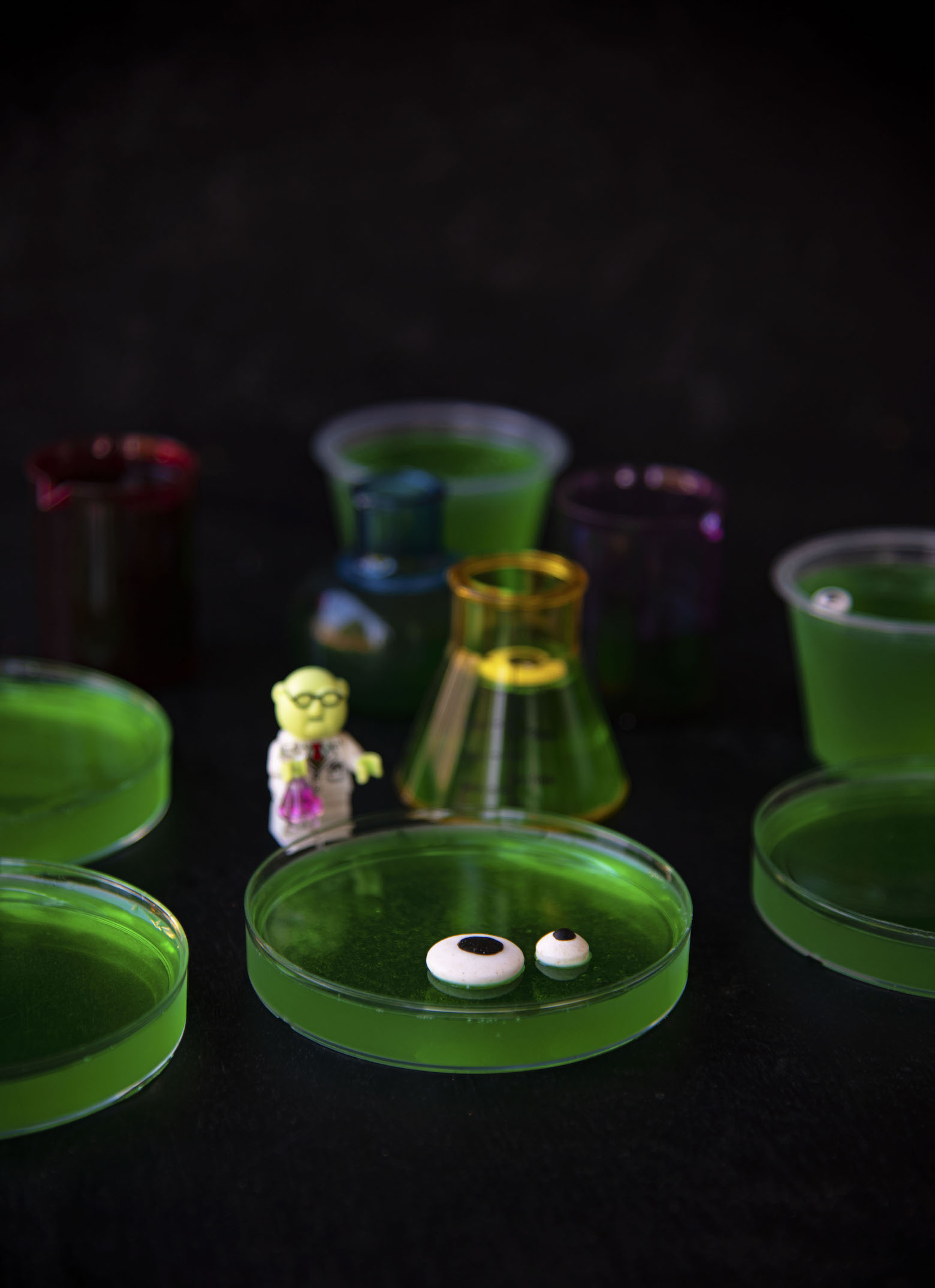 Side view of Petri Dish Jello Shots with Mr Bunsen Honeydew figurine 