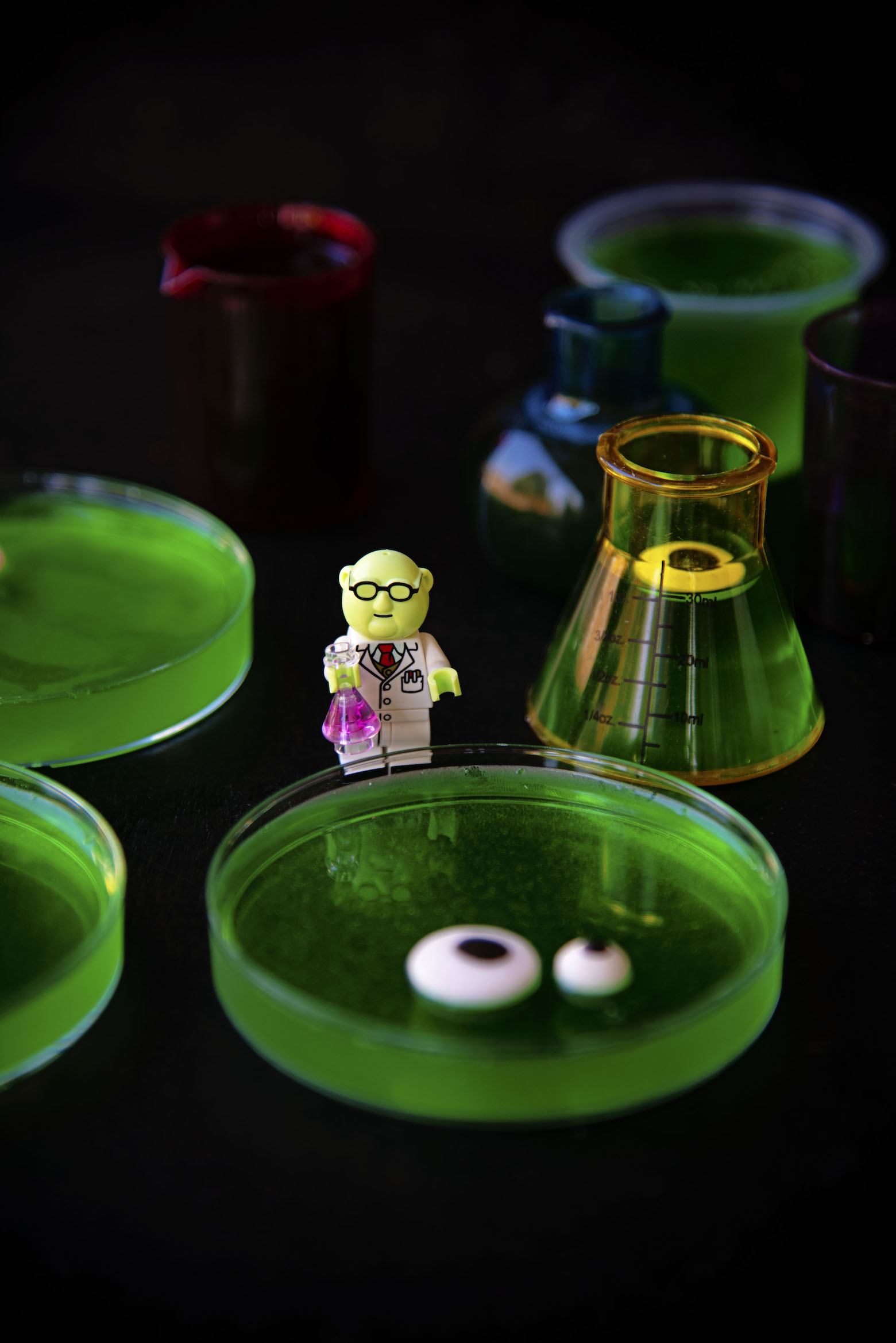 Close up of Mr Bunsen Honeydew figurine next to petri dishes with eyeballs. 