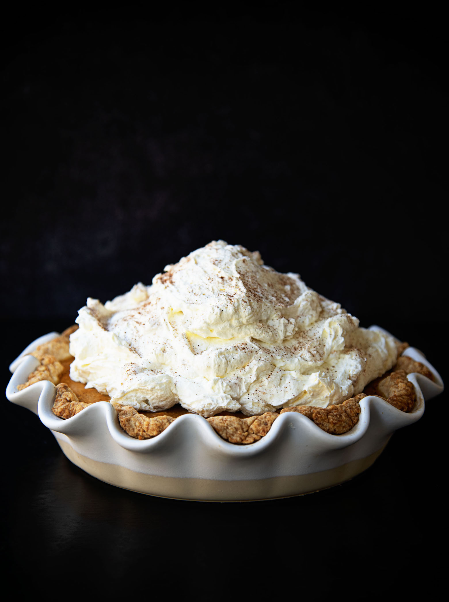 Full Snickerdoodle Pumpkin Cream Cheese Pie topped with piles of whipped cream. 