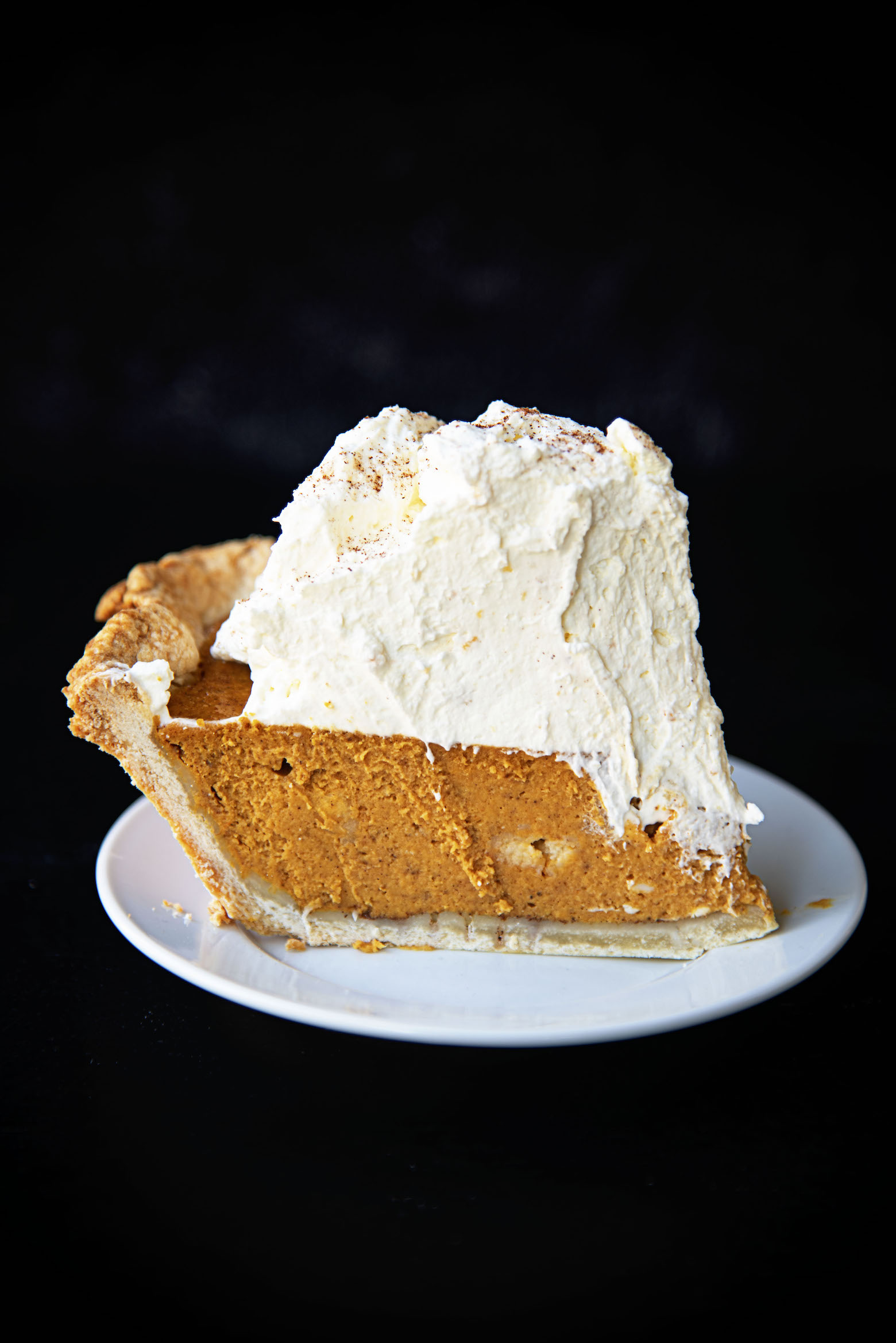Slice of Snickerdoodle Pumpkin Cream Cheese Pie on a small white plate 