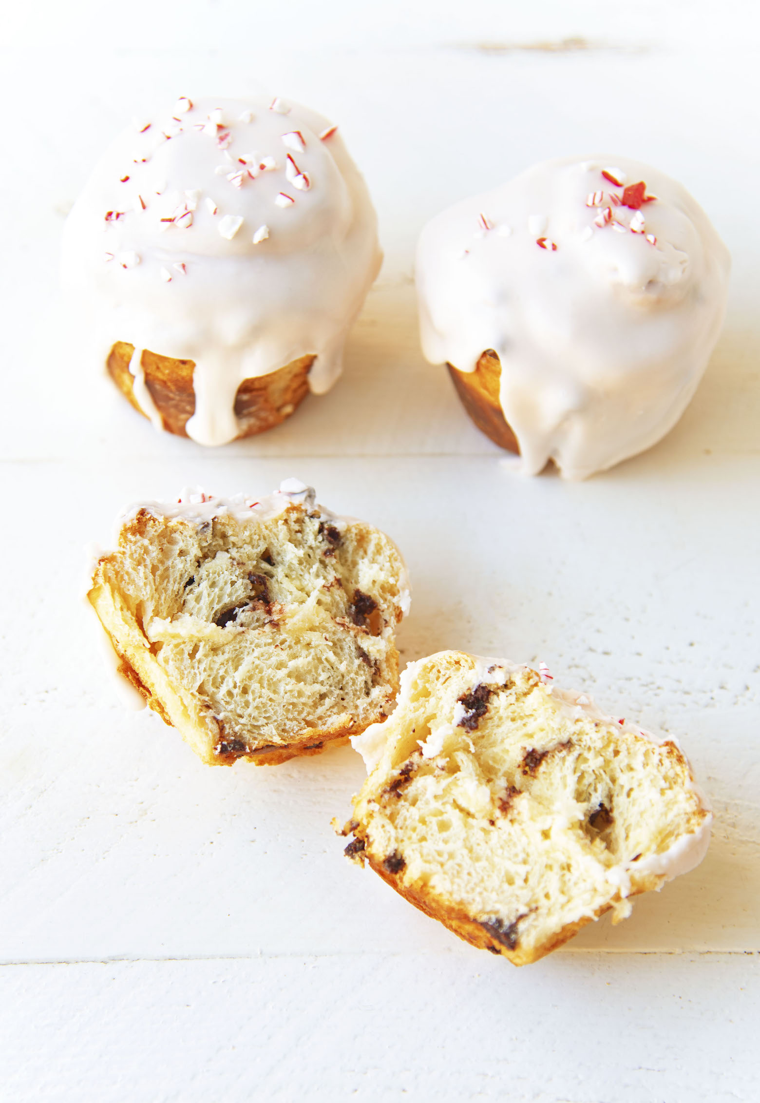 Three sweet rolls with the first one being cut open and two sides fanned out. 