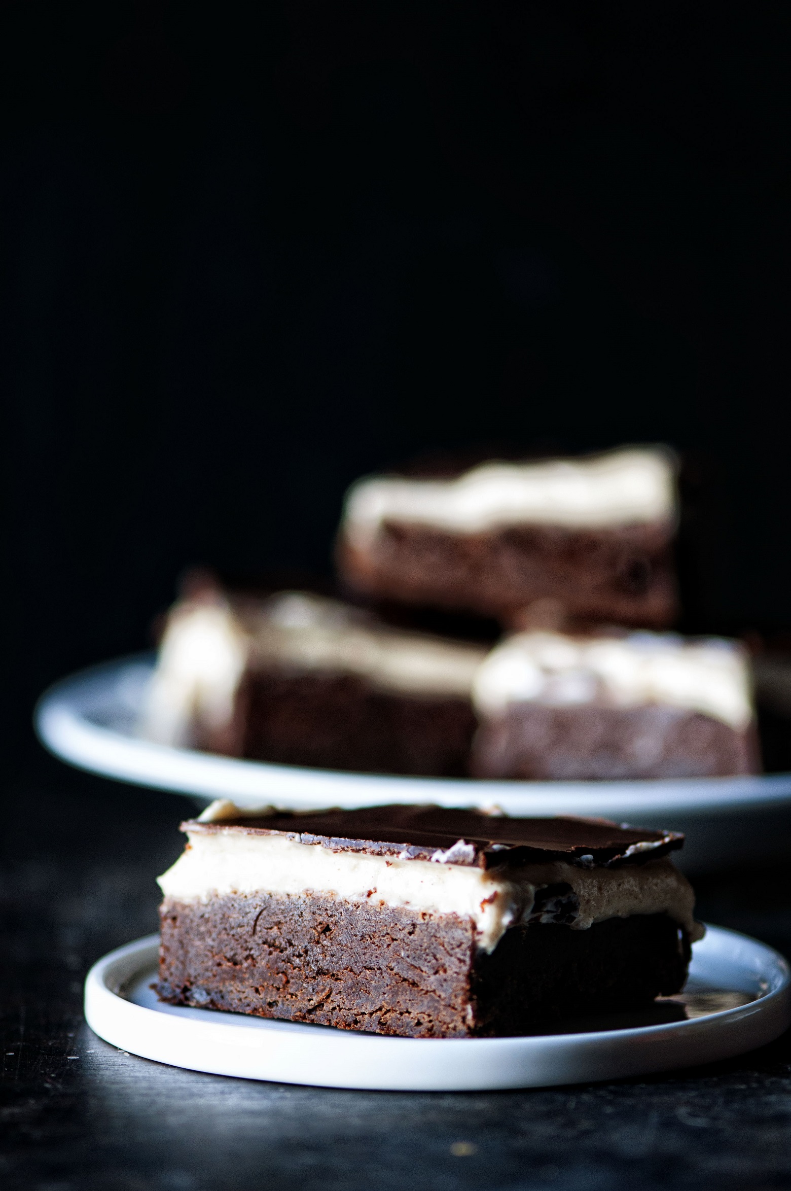 Plate of Cinnamon Dolce Latte Brownies with a brownie up front on a small white plate. 