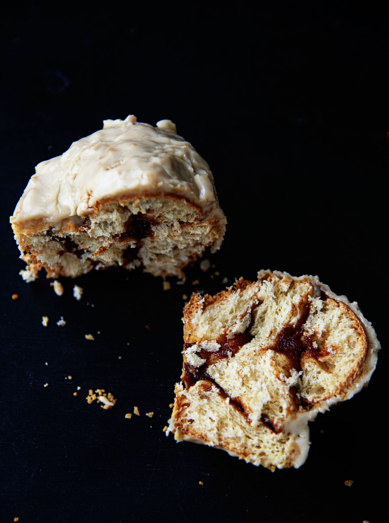 Salted Maple Cinnamon Roll cut in half with one half laying in front of the other