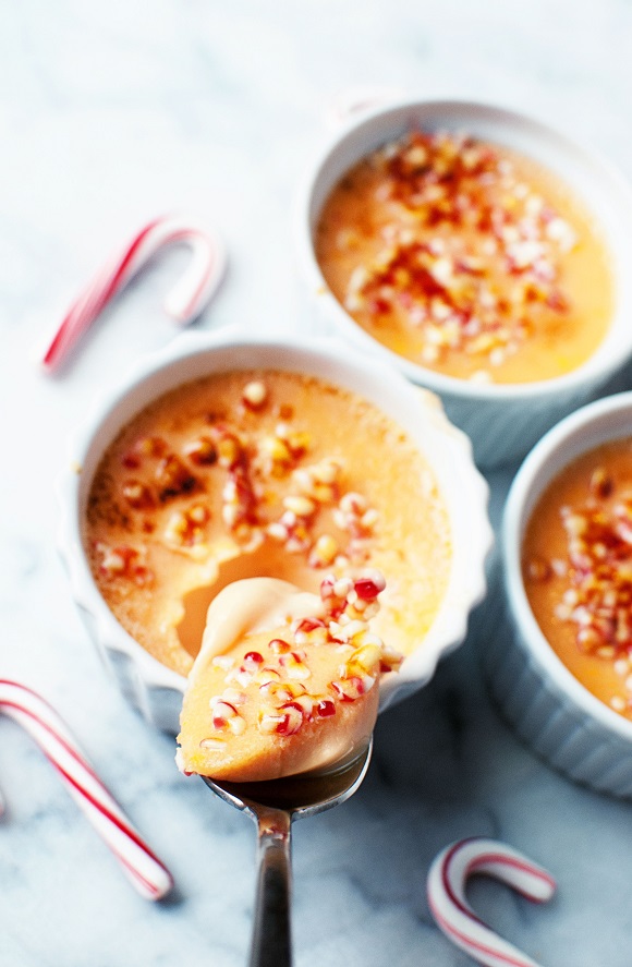Shot of spoon with creme brulee on it with containers of creme brulee below 