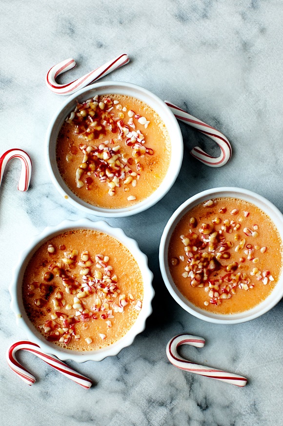 Overhead shot of three creme brulee with scatter candy canes. 